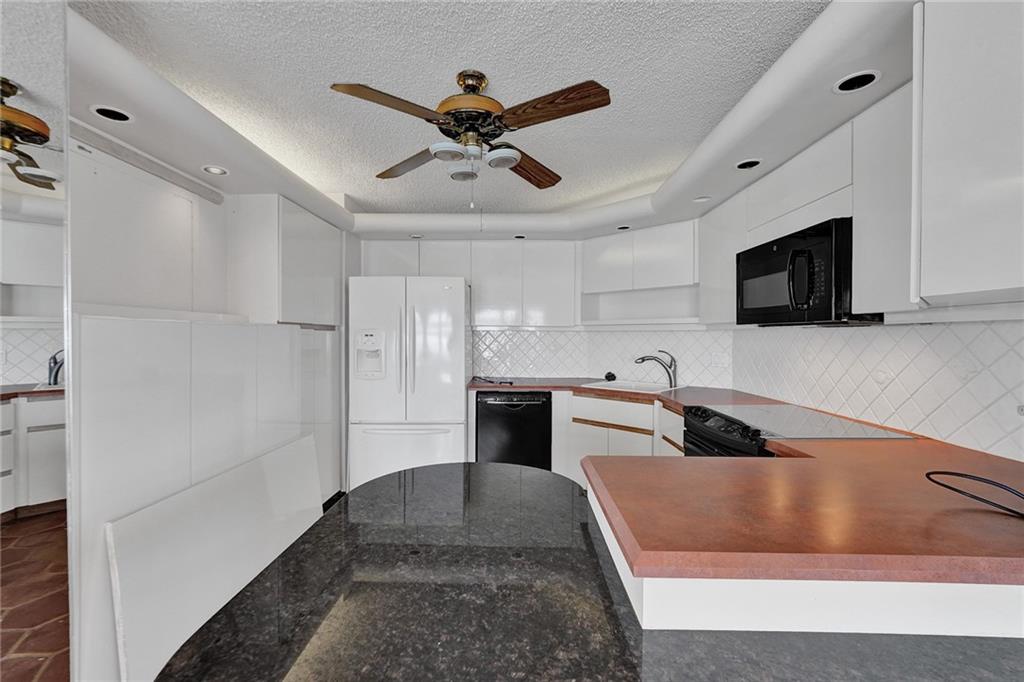 The best thing here is to take down the wall where the sink and the microwave are, and open the kitchen up to the beautiful ocean views.