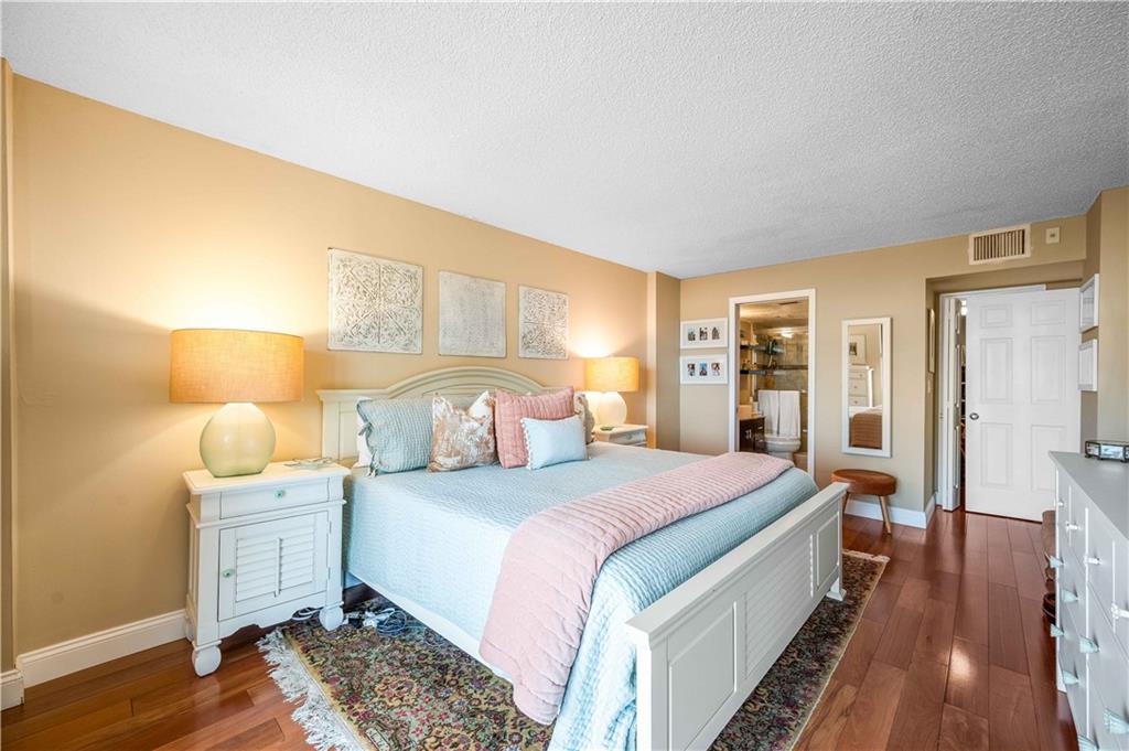 Gleaming wood flooring throughout the master bedroom.