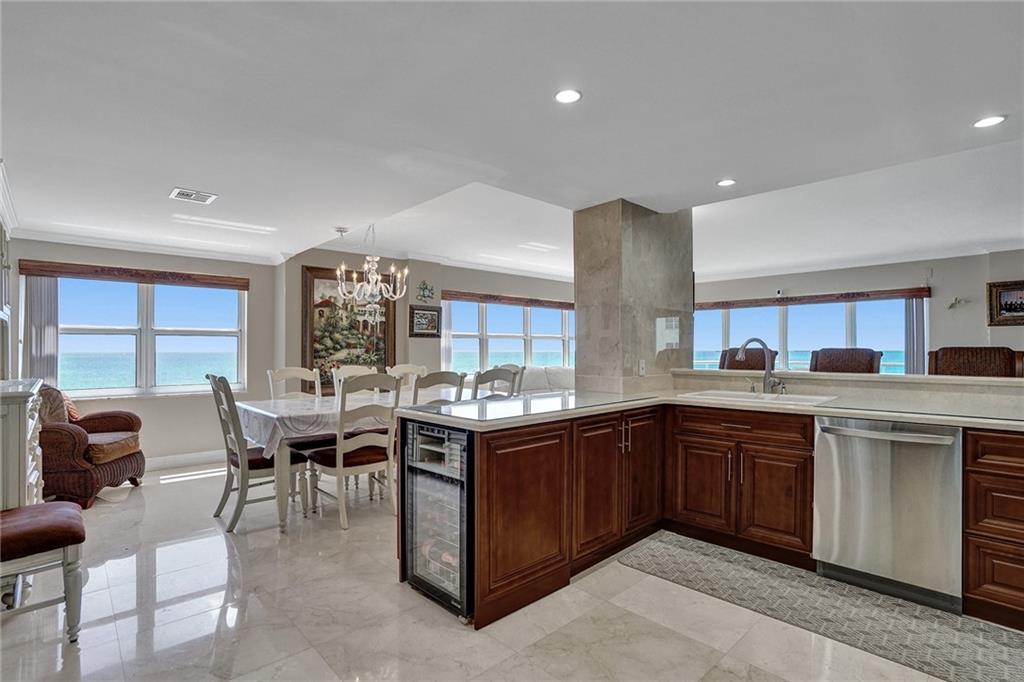 The kitchen, facing into the dining room. There is a wine refrigerator at the end of the kitchen counter.