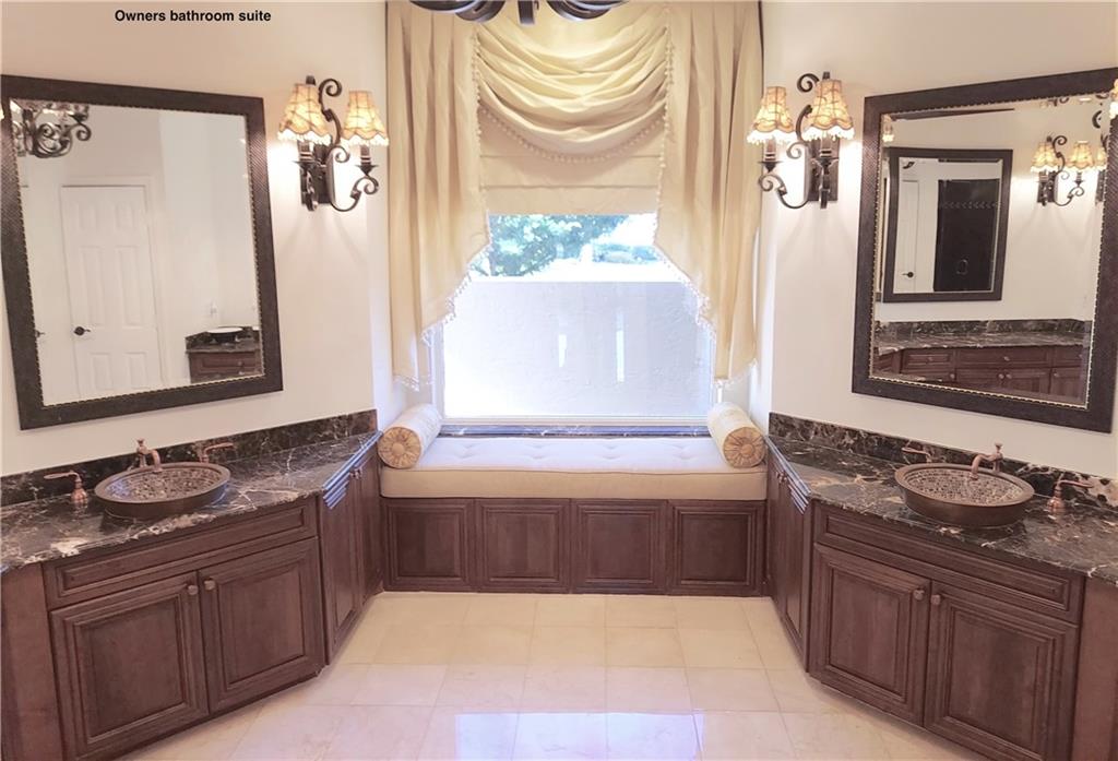 Owners bathroom has dual vanities.