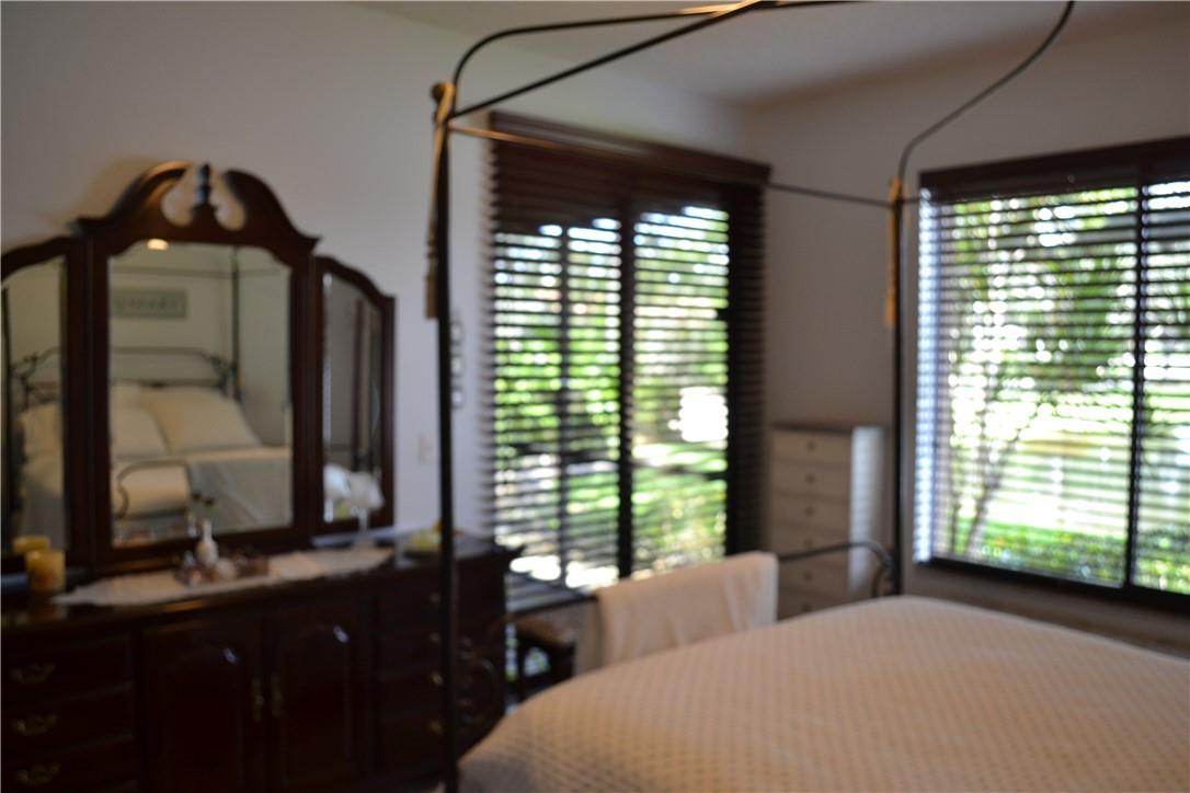 MASTER BEDROOM WITH WINDOW AND SLIDING GLASS DOORS TO SCREENED PATIO WITH THAT BEAUTIFUL LAKE VIEW THAT'S ALL YOURS TO ENJOY.