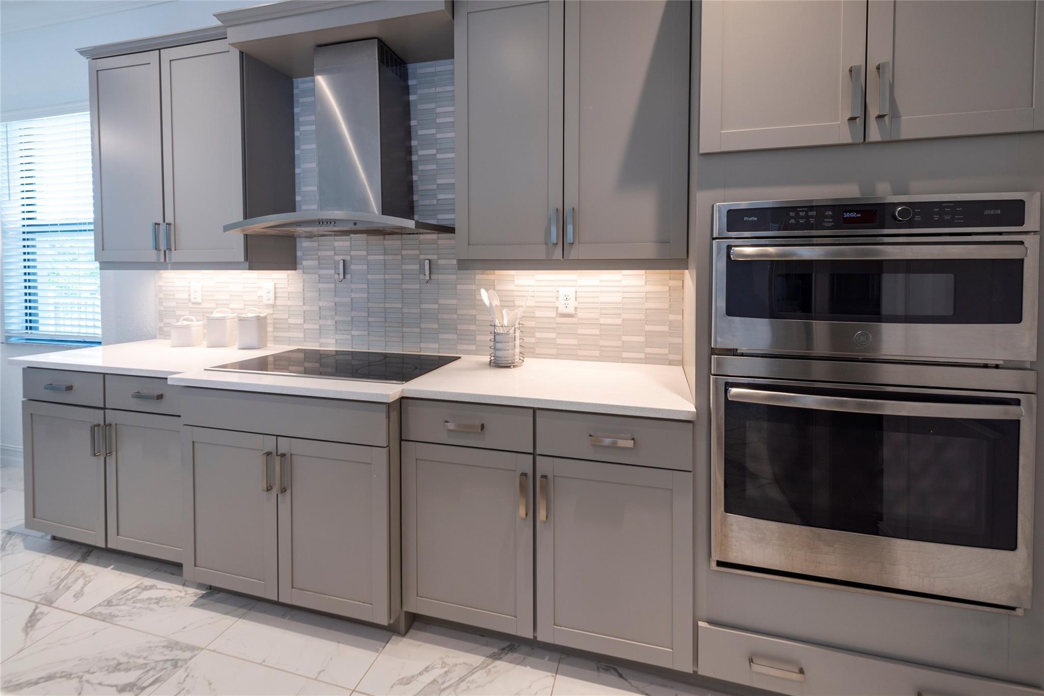 YOUR GORGEOUS KITCHEN WITH STAINLESS STEEL APPLIANCES, RANGE HOOD, UNDER CABINET LIGHTING, BEAUTIFUL BACKSPLASH AND SPARKLING QUARTZ COUNTERS IS READY FOR ENTERTAINING!