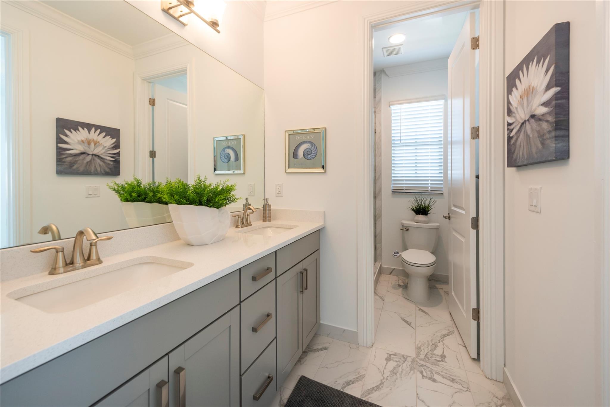 THIS LOVELY 2ND FLOOR JACK AND JILL BATHROOM HAS BEAUTIFUL CABINETRY WITH TWO LARGE SINKS, PLENTY OF COUNTER SPACE, AND PRIVATE WATER CLOSET WITH SHOWER