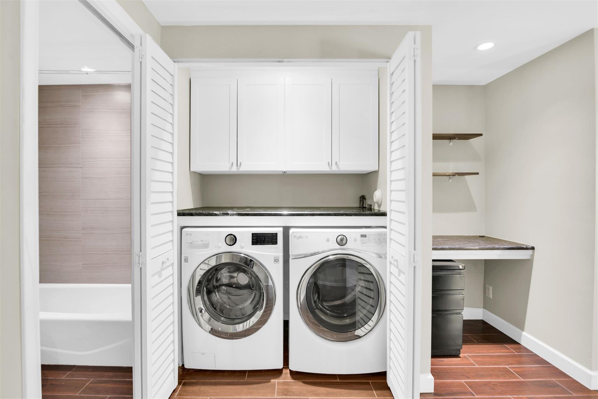 Custom Granite counter hidden laundry room in master with cabinetry