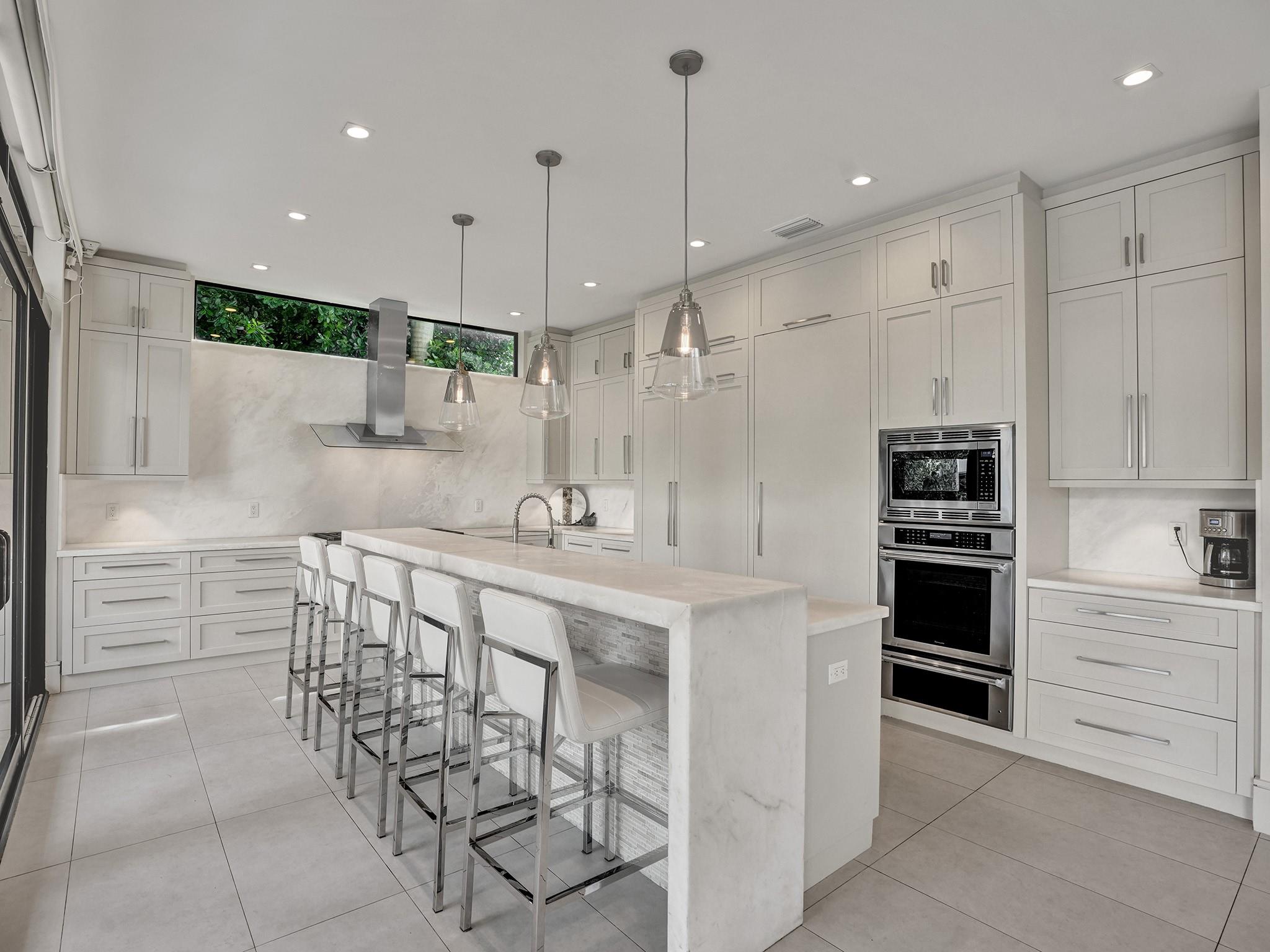 Attractively tiled breakfast bar seating! Huge hidden pantry and laundry!