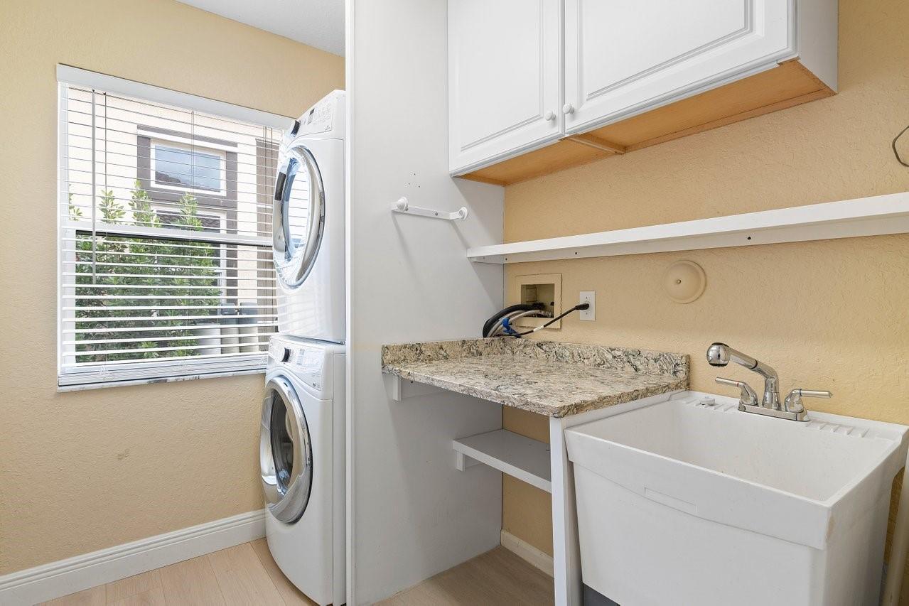 Seperate laundry room has sink, cabinets and folding area