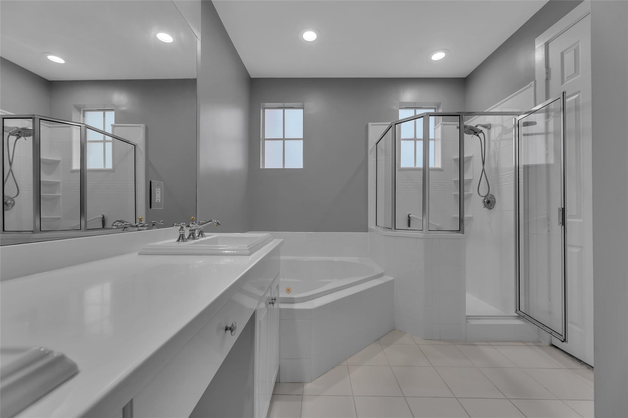 Master bathroom features walk in shower and large tub with jets