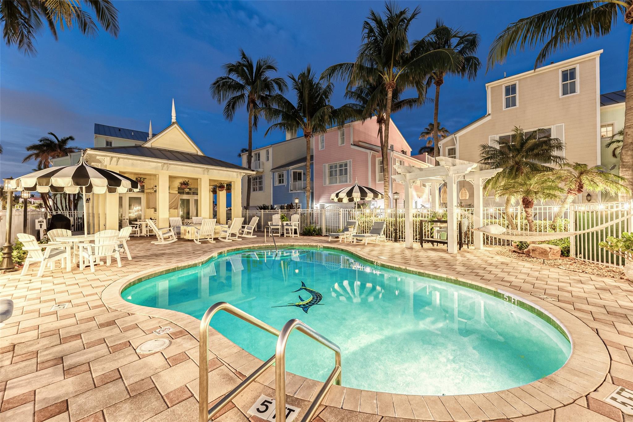 Community pool with tables, umbrellas, lounge chairs, fire pit ans more