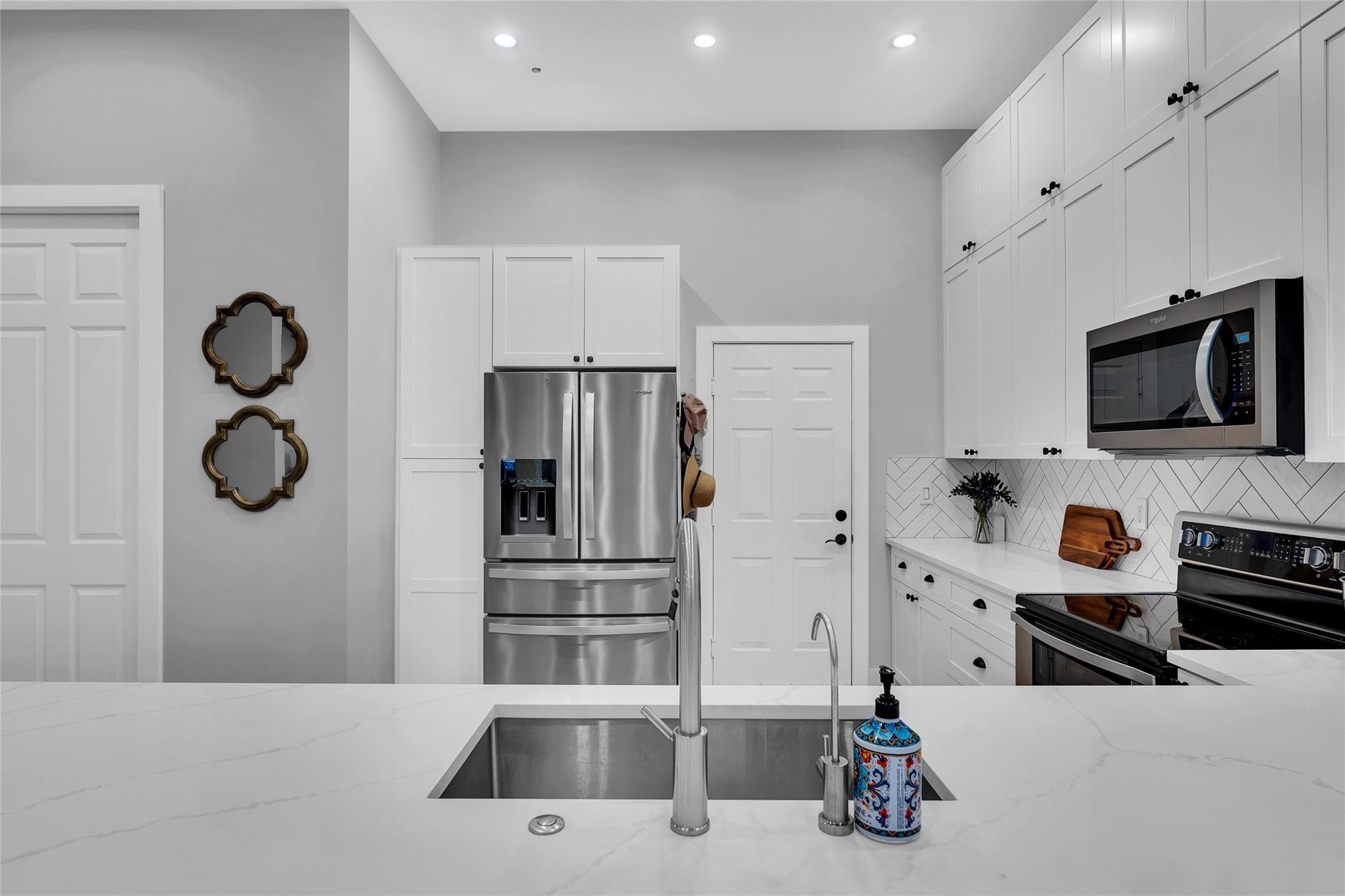 Updated new kitchen is fresh and bright and offers white subway tile backsplash in chevron pattern