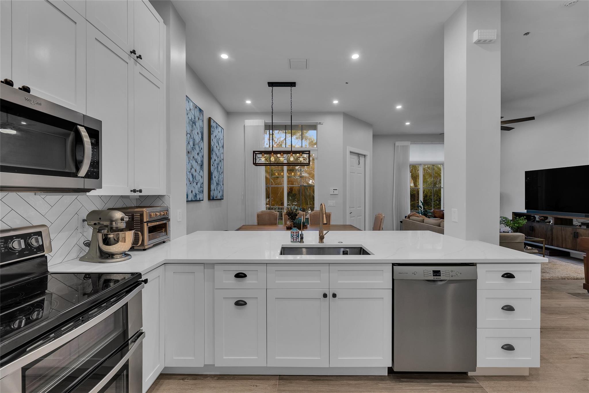 Open and updated kitchen with white shaker cabinets and large breakfast bar