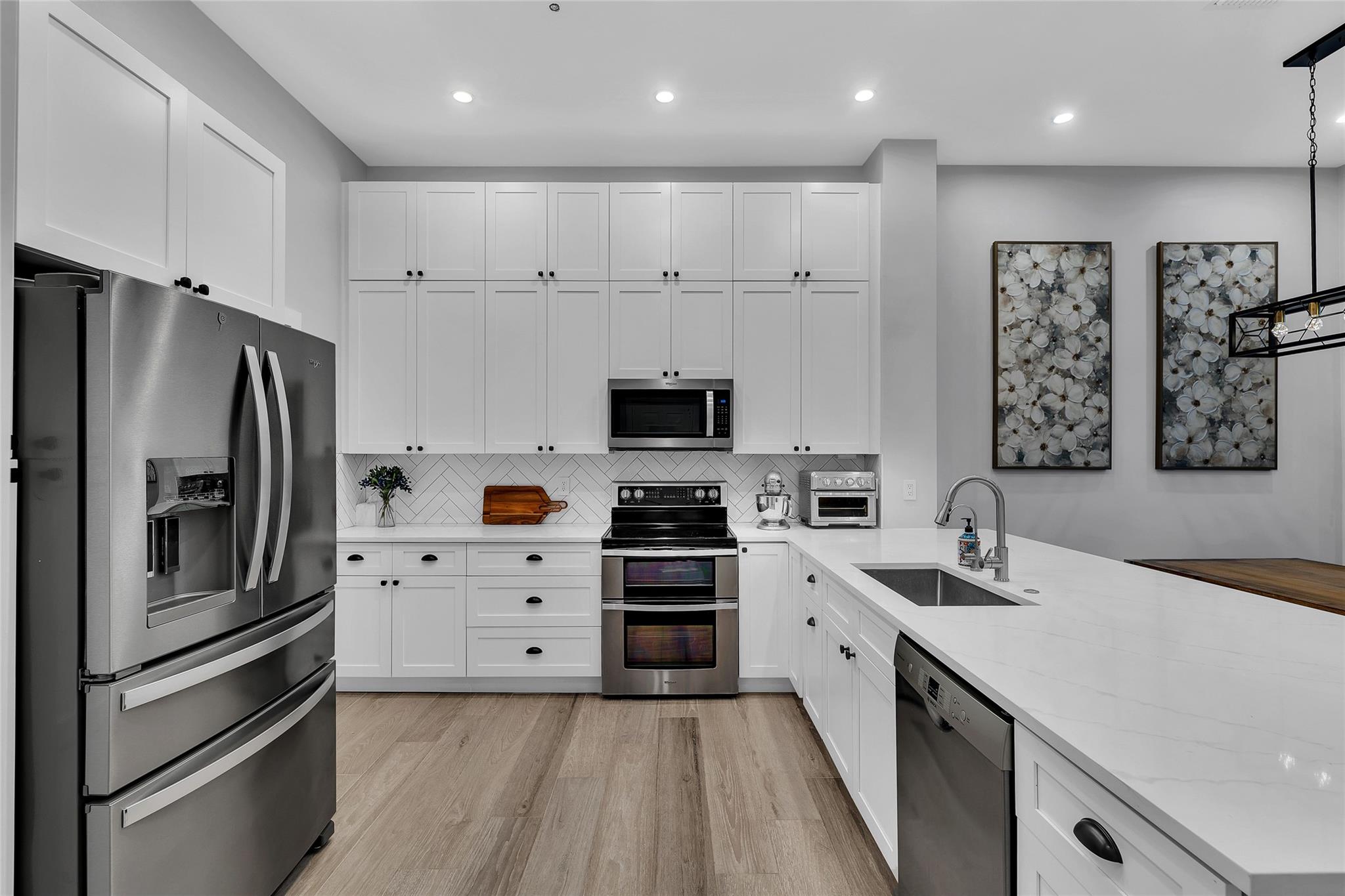 Updated kitchen with white shaker cabinets and quartz counters