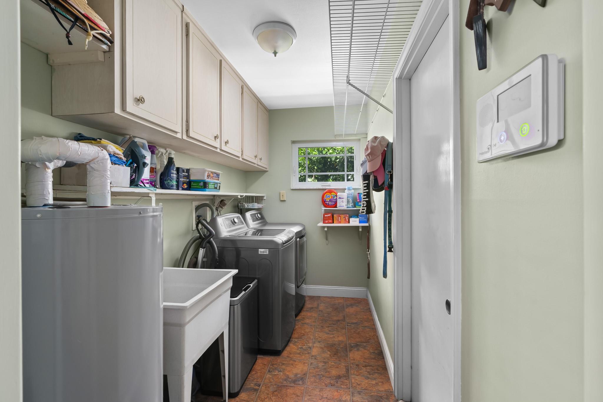 Laundry room off of kitchen has plenty of storage and a mud sink!