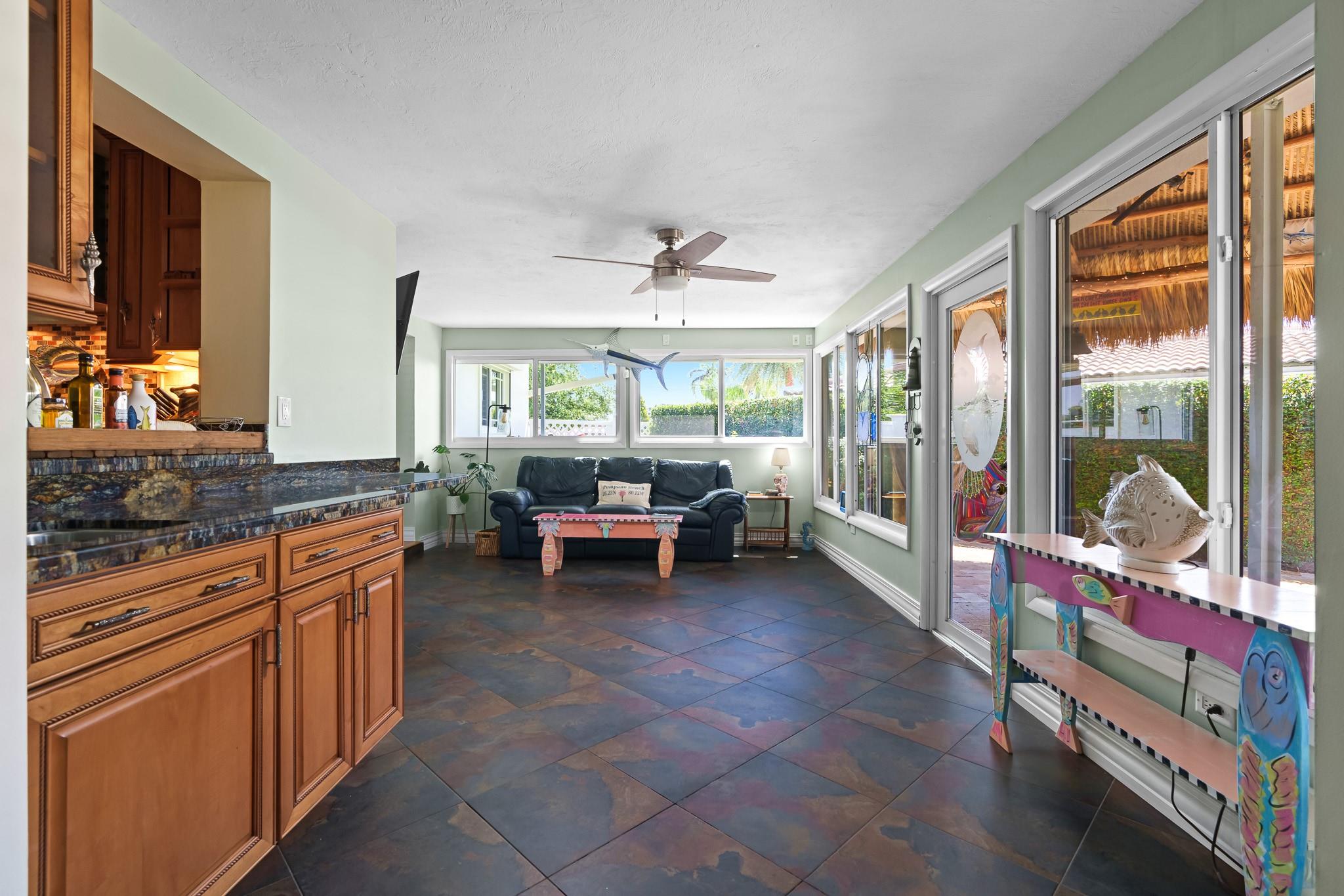 Wet bar and fantastic, bright Florida room that runs along the south side of the home and leads out to back patio/tiki area and waterfront