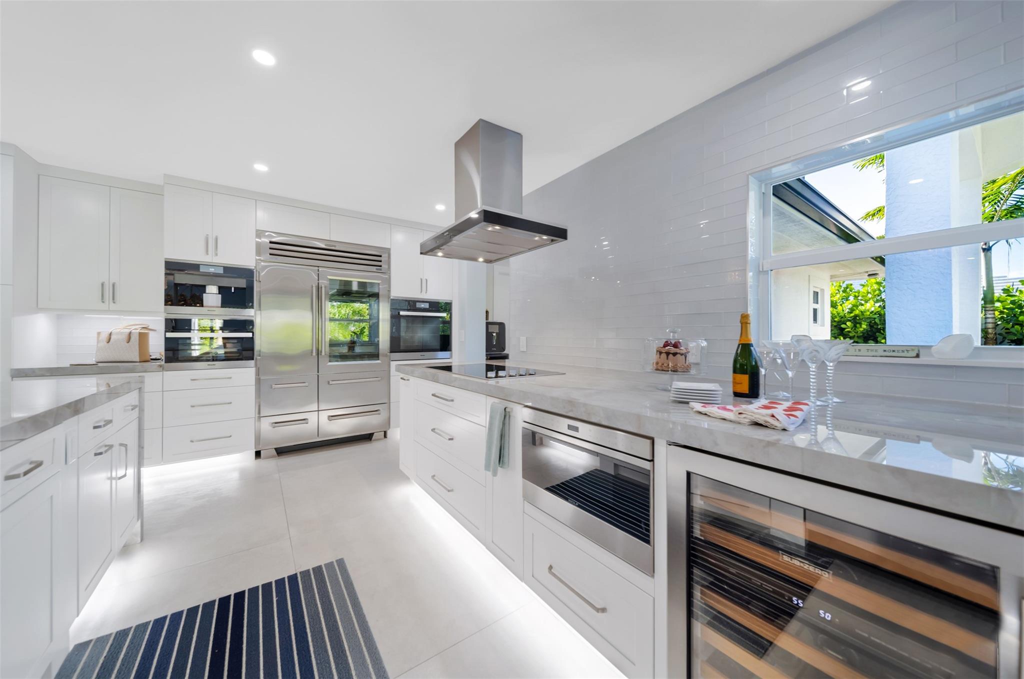 Wolfe wine cooler & drawer micro oven, window with view to the outdoor sitting area & pool.