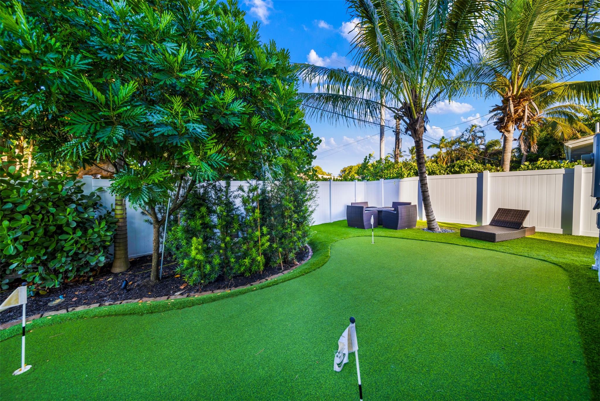 4 hole putting green and 4 person sitting area with a gas fire pit.