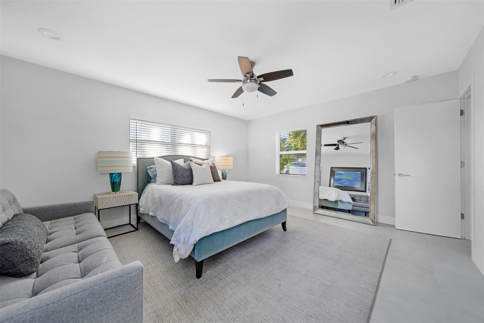 bedroom #3 with queen size bed, sofa and full length mirror.