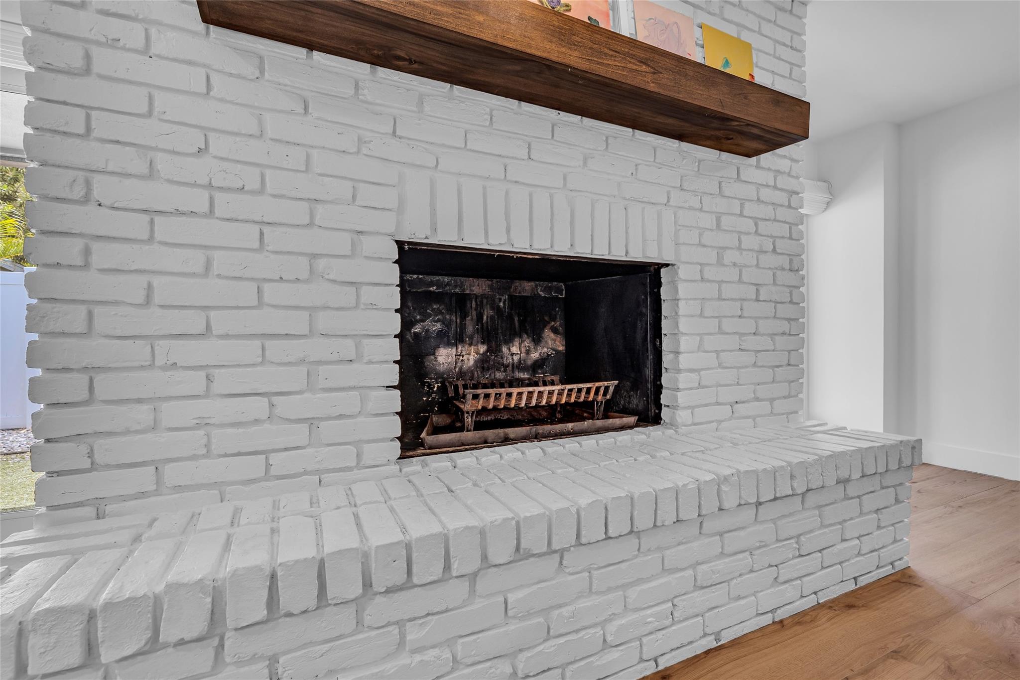 White brick wood burning fireplace with wood mantle
