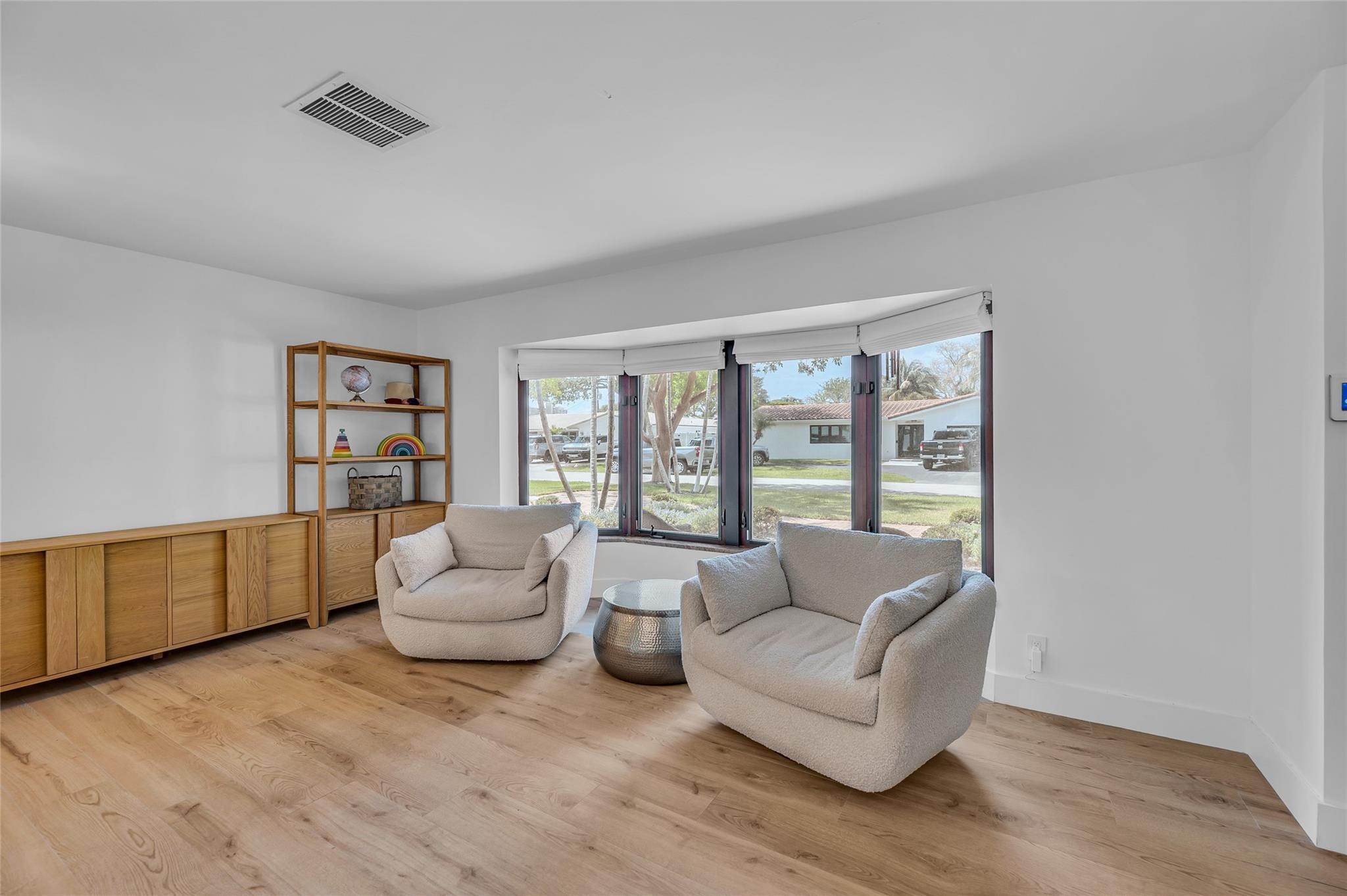 Living room offers large bay window and wood plank tile flooring
