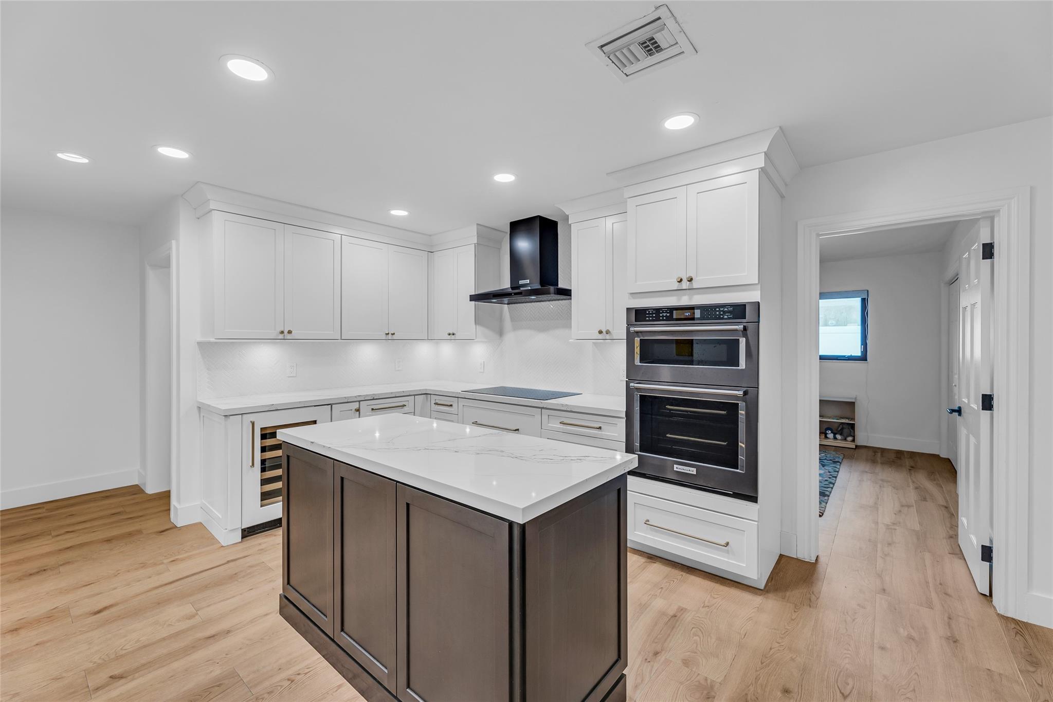 Spacious and updated kitchen with center island and wood plank tile flooring