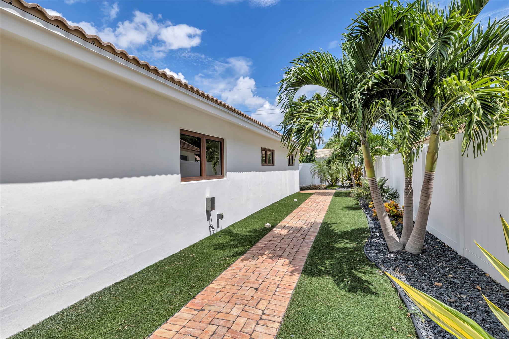 Turf backyard and side yard with tropical landscaping