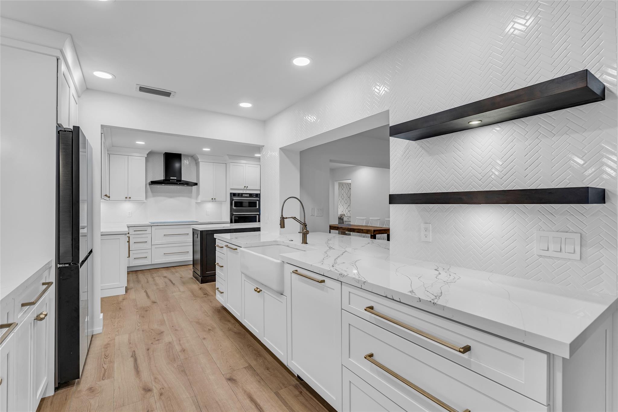 White chevron tile backsplash, quartz counters, restoration hardware accents and tons of upgrades in the remodeled kitchen