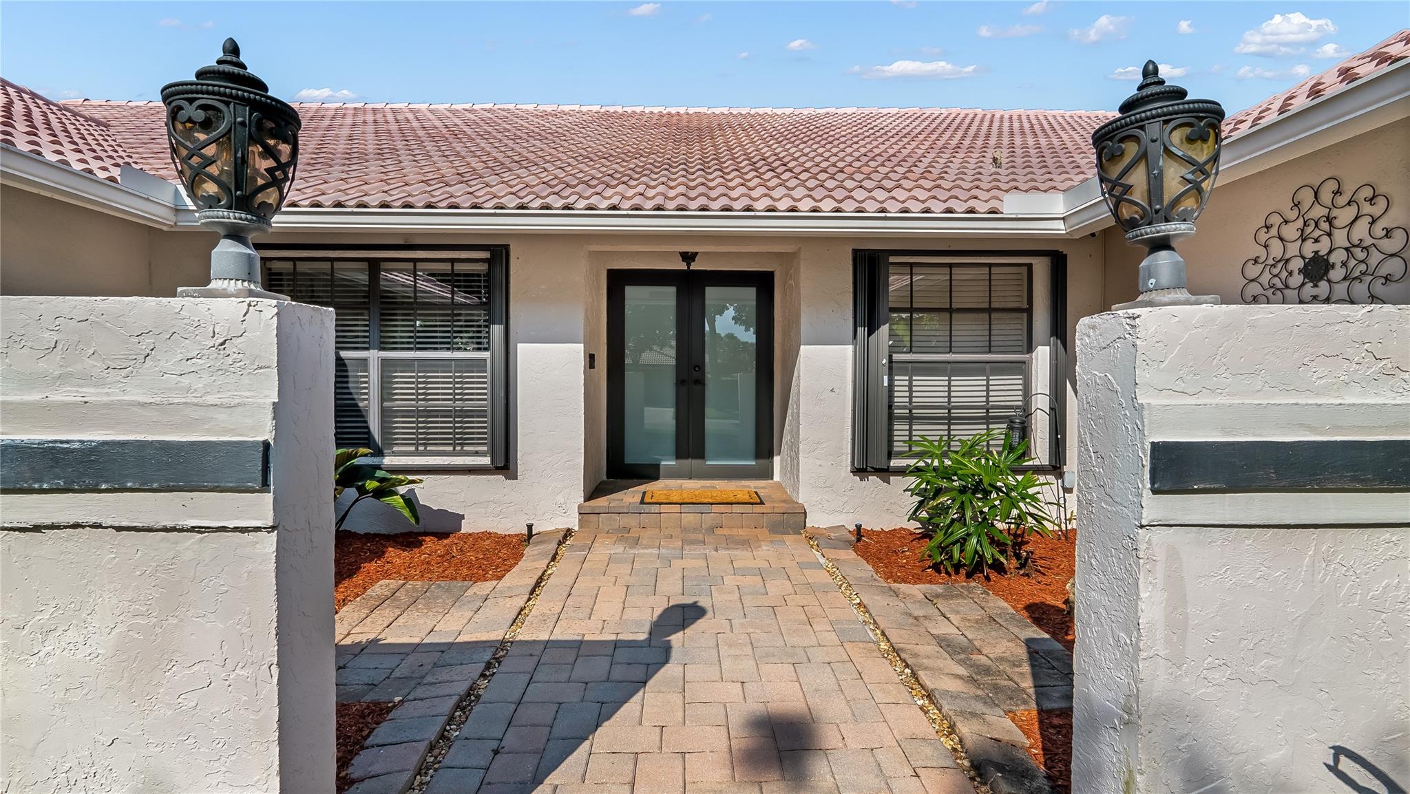 Approach the front door along a charming walkway that guides you through the beautiful landscape scenery. Where lush greenery and carefully placed pavers create an inviting path to your new home.