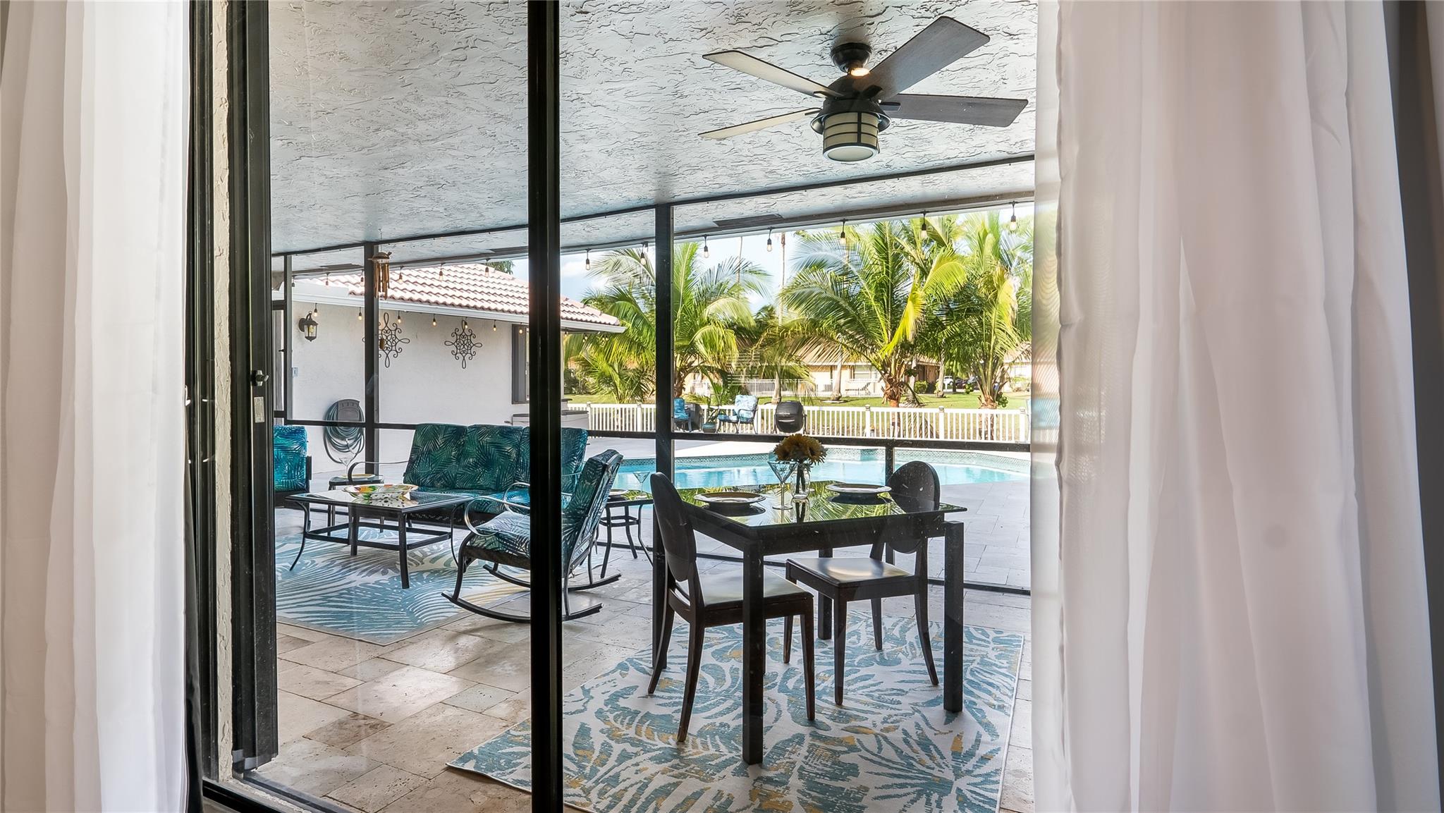 Just beyond the sleek glass doors lies a true outdoor living oasis - the spectacular covered patio space. This exceptional extension of the home seamlessly blends interior comfort with the beauty of Florida's lush natural surroundings.