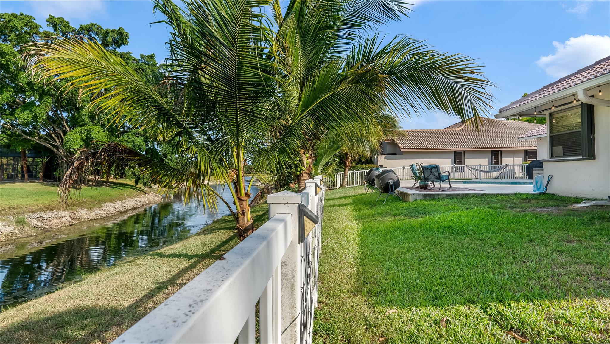 The well-maintained lawn and mature landscape is equipped with an automatic sprinkler system, ensuring the greenery stays vibrant year-round. Enjoy the coconuts and mangoes!