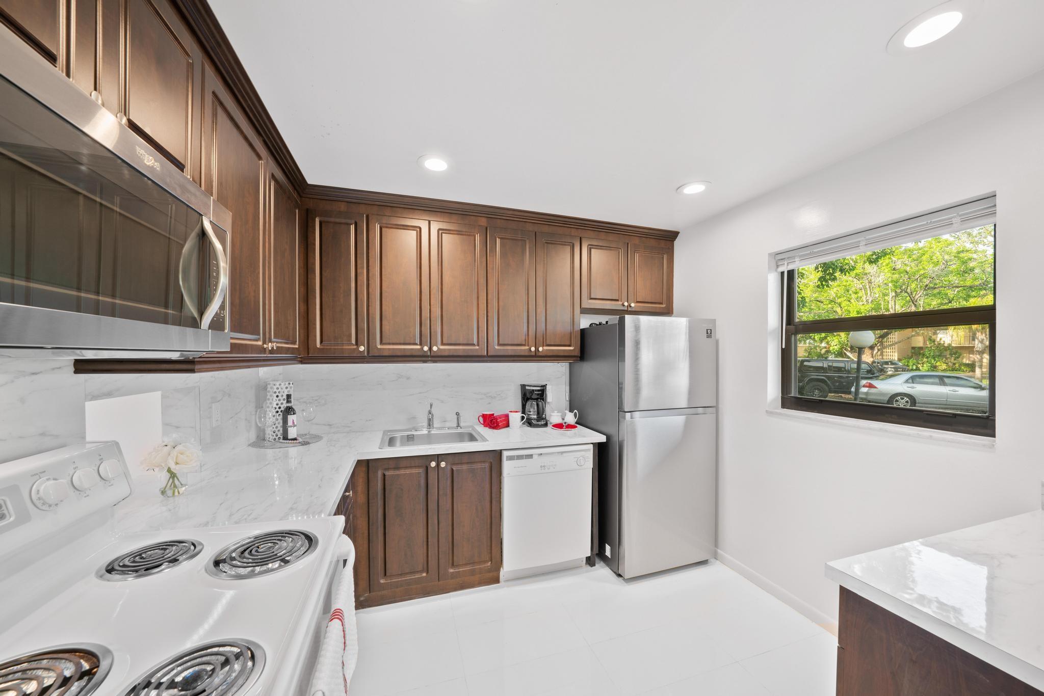 The 10' x 9' kitchen features a Samsung SS refrigerator, window for natural sunlight and snack bar/storage/pantry.