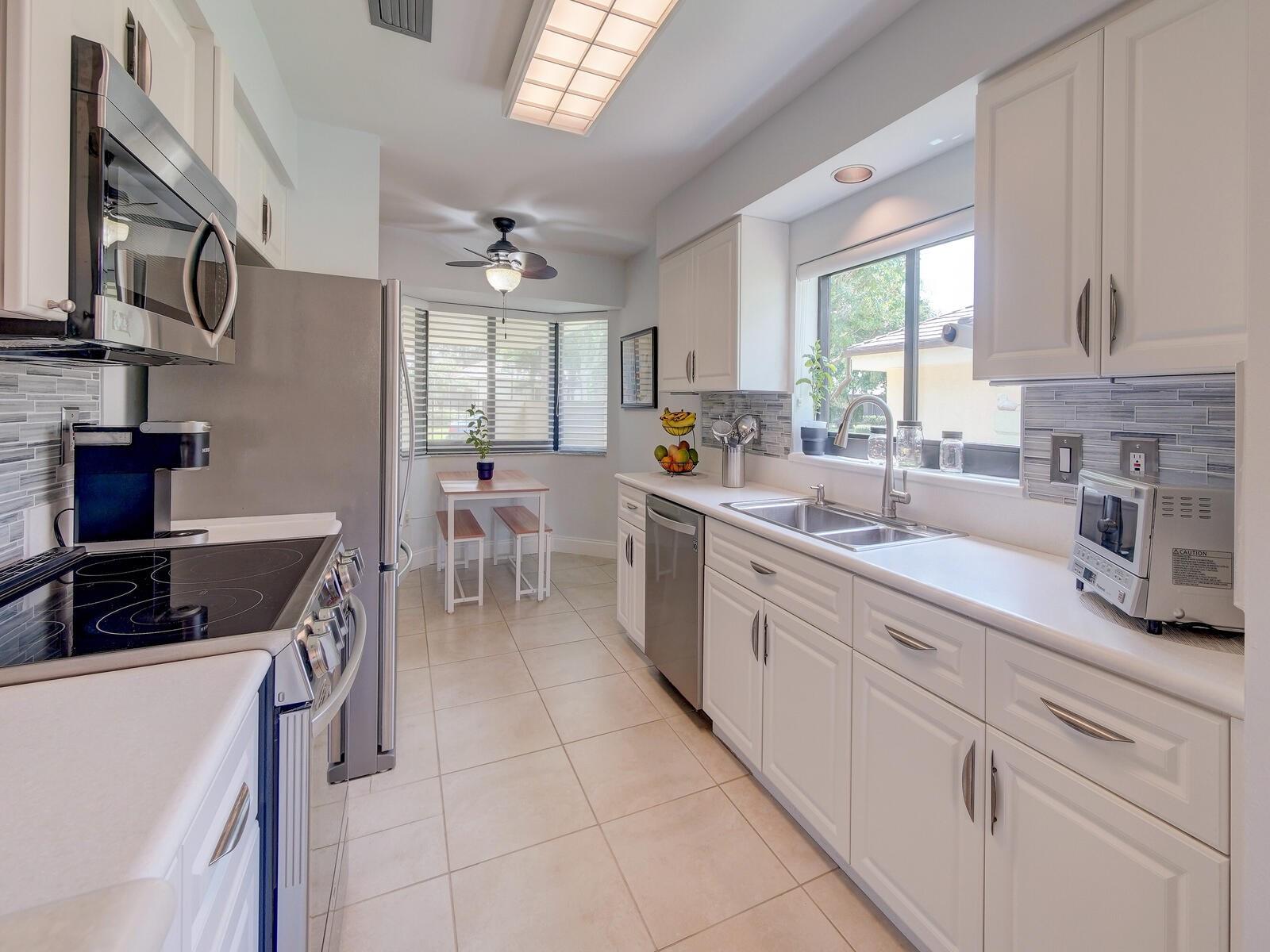 White and bright kitchen with all Stainless-Steel appliances. New modern backsplash!