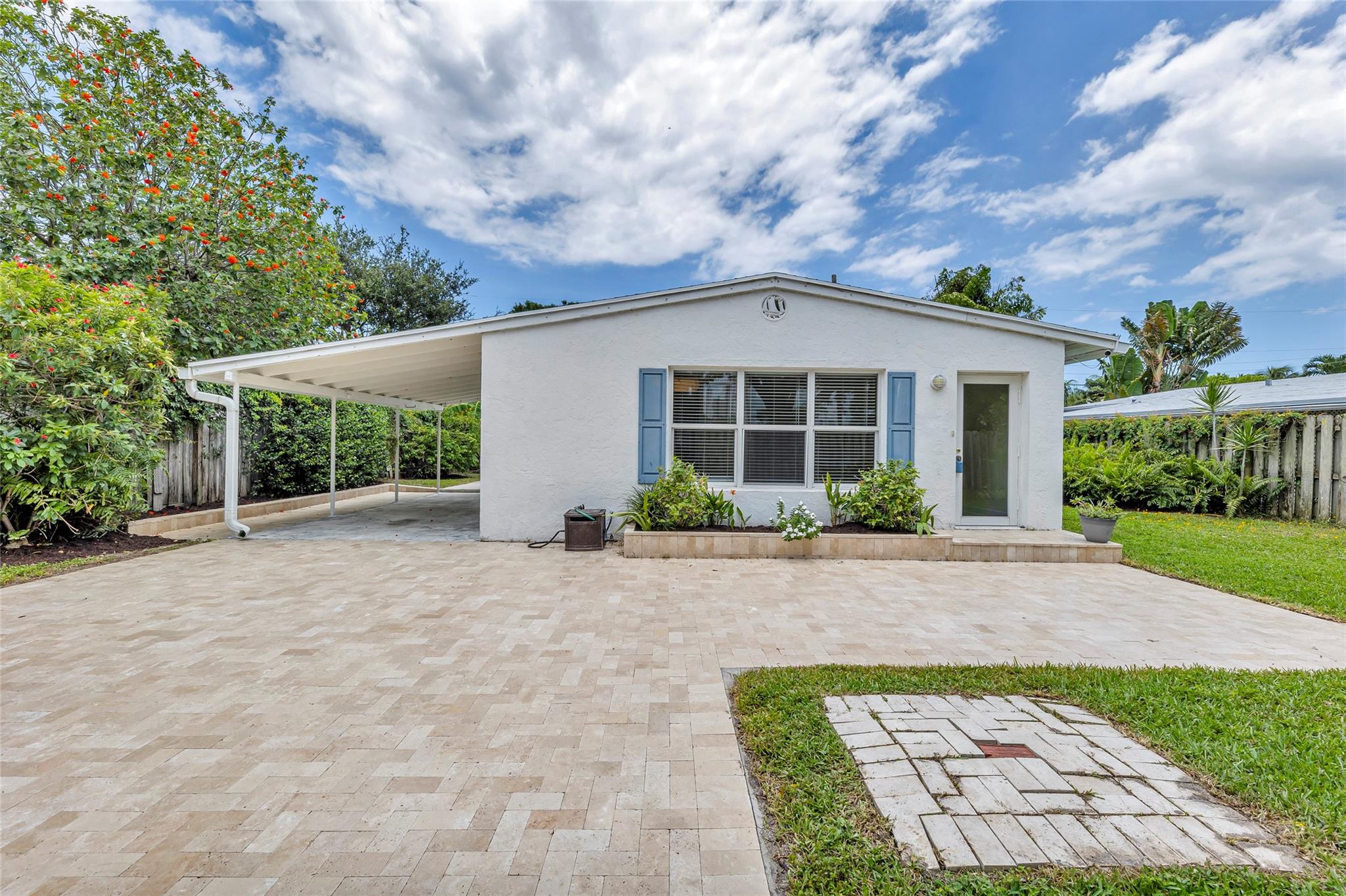 Front entrance with large patio, driveway, carport