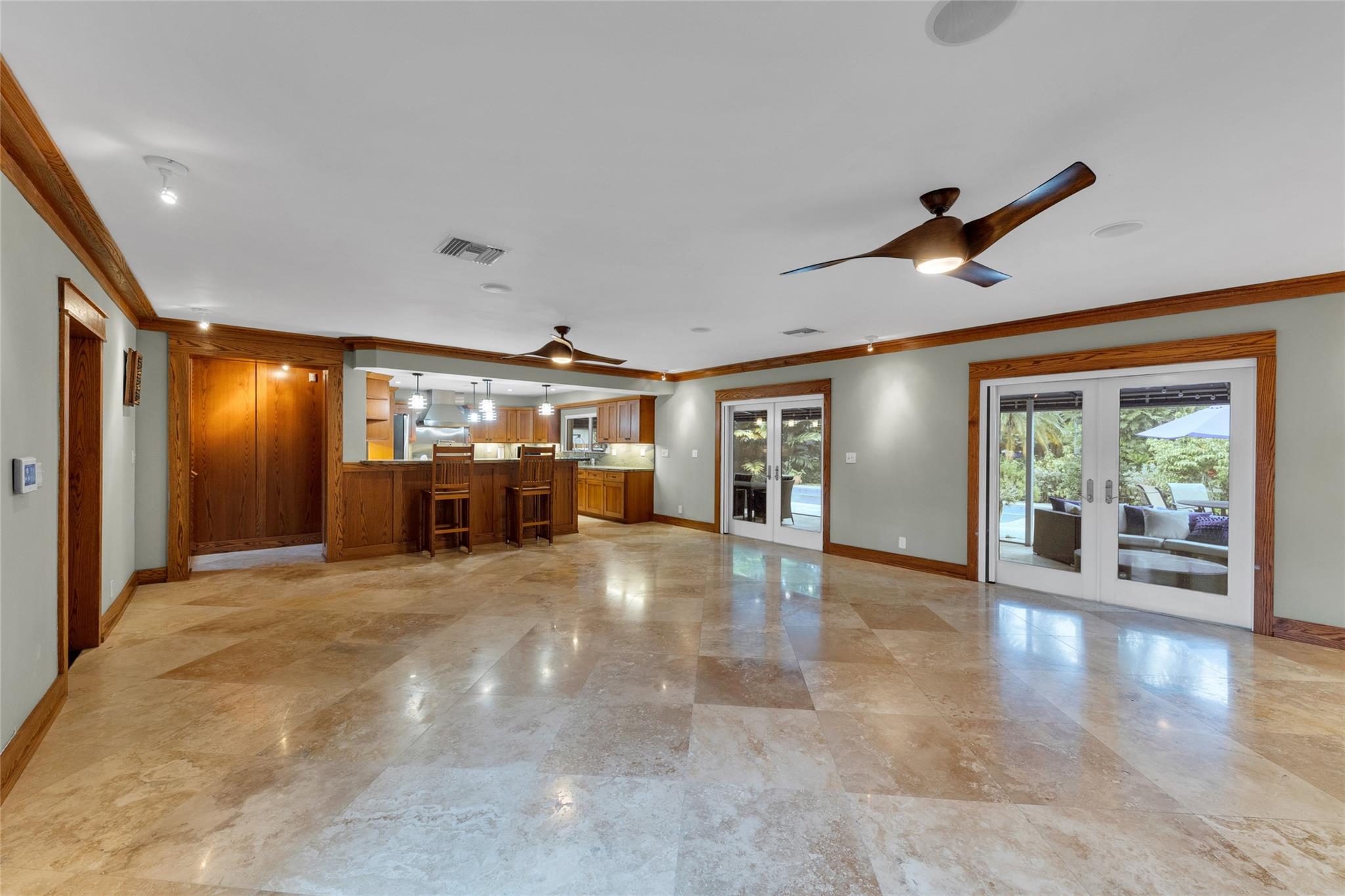 Living Room with View to Kitchen and Large Screened Patio Overlooking the Pool
