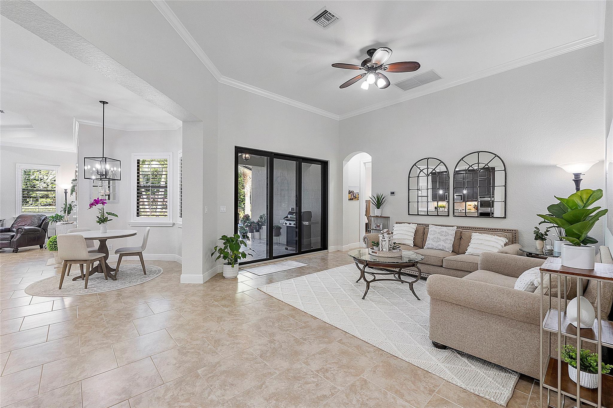 Open floor plan layout with Living room, eat-in dining, Italian tile flooring, plantation shutters throughout, & crown moldings.