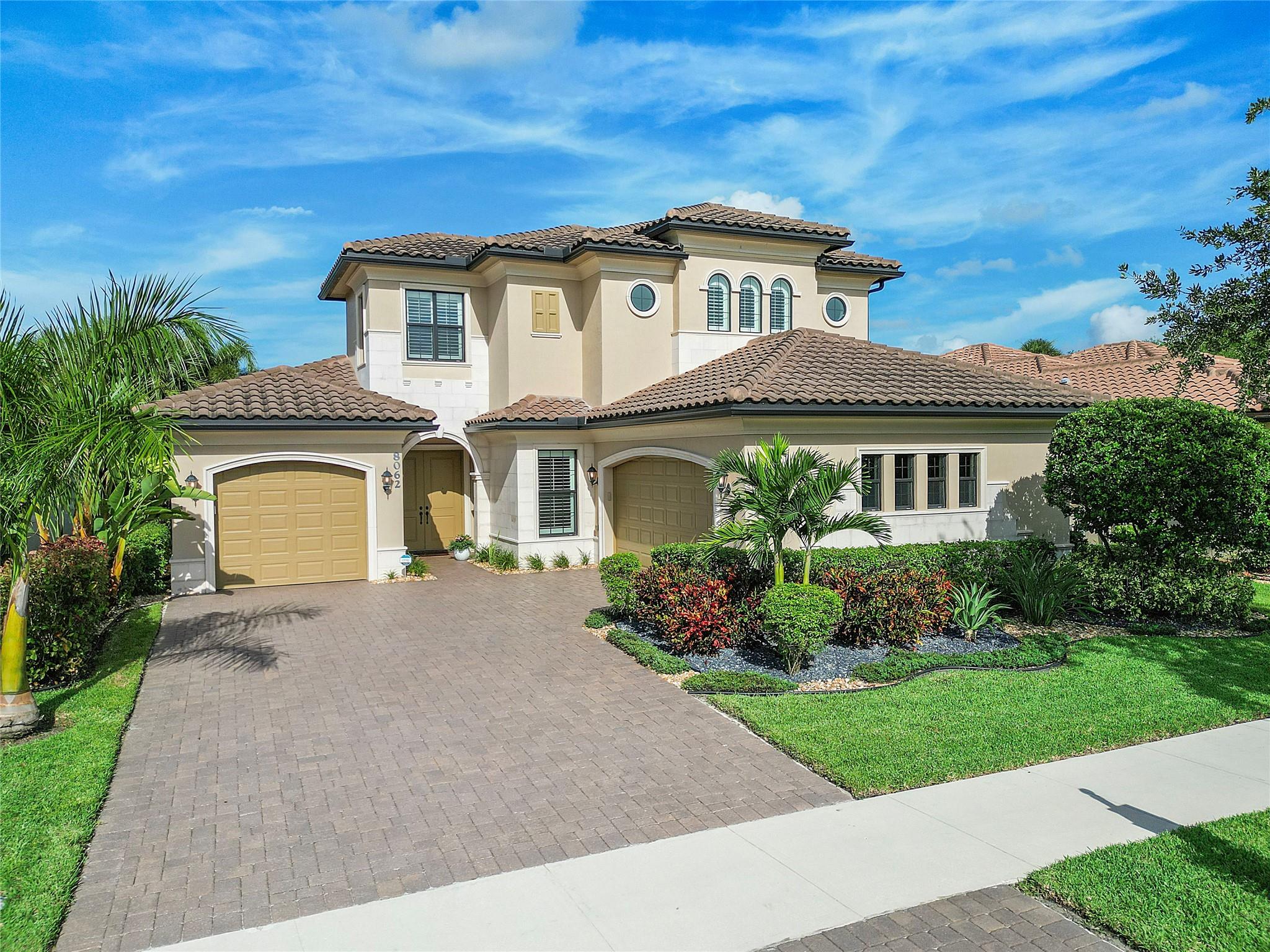 Daytime view of front elevation of 2 story 4 bedroom plus loft, 3 bathroom pool home