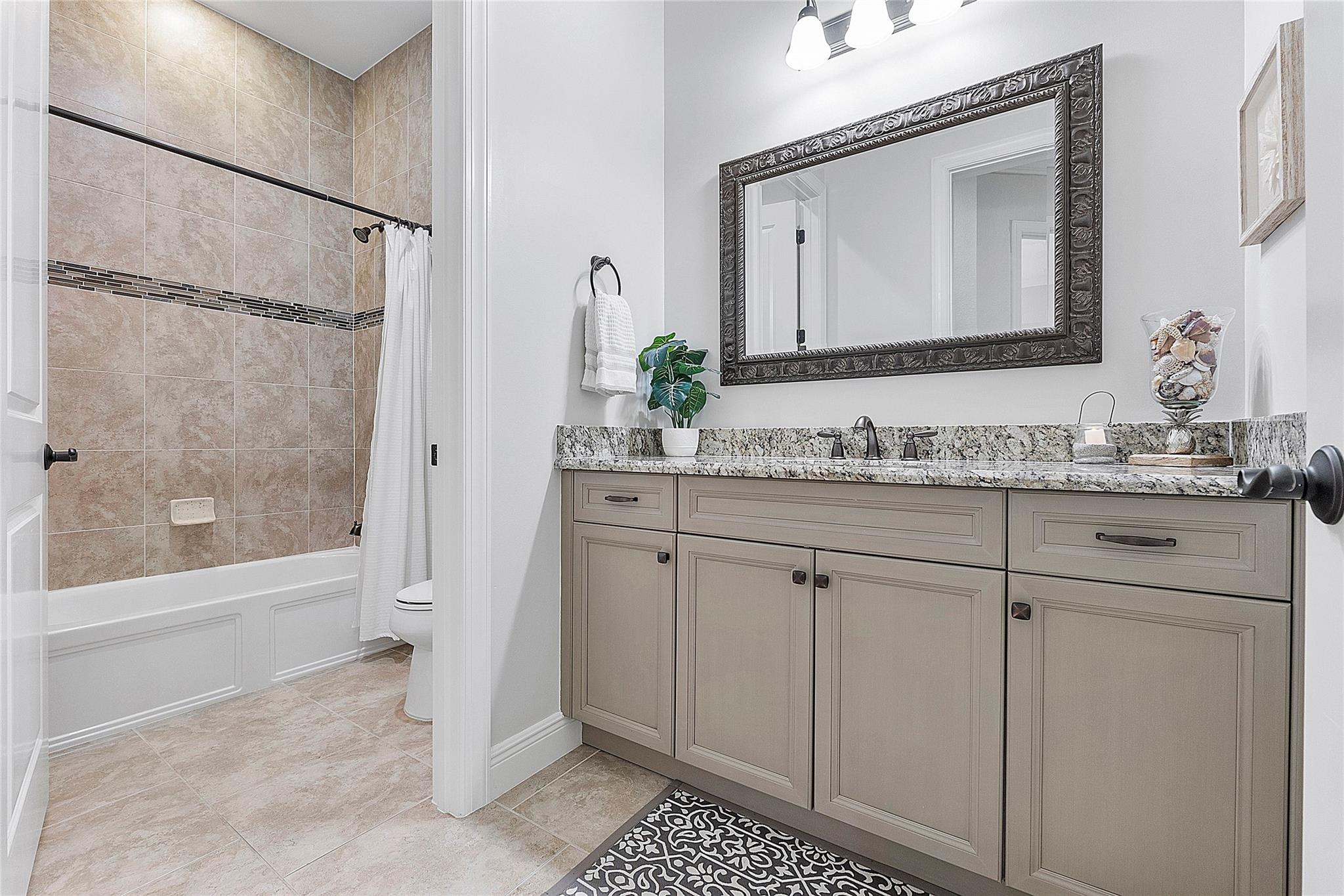 Full guest bathroom with Italian tile, Brianna cabinetry & marble countertops