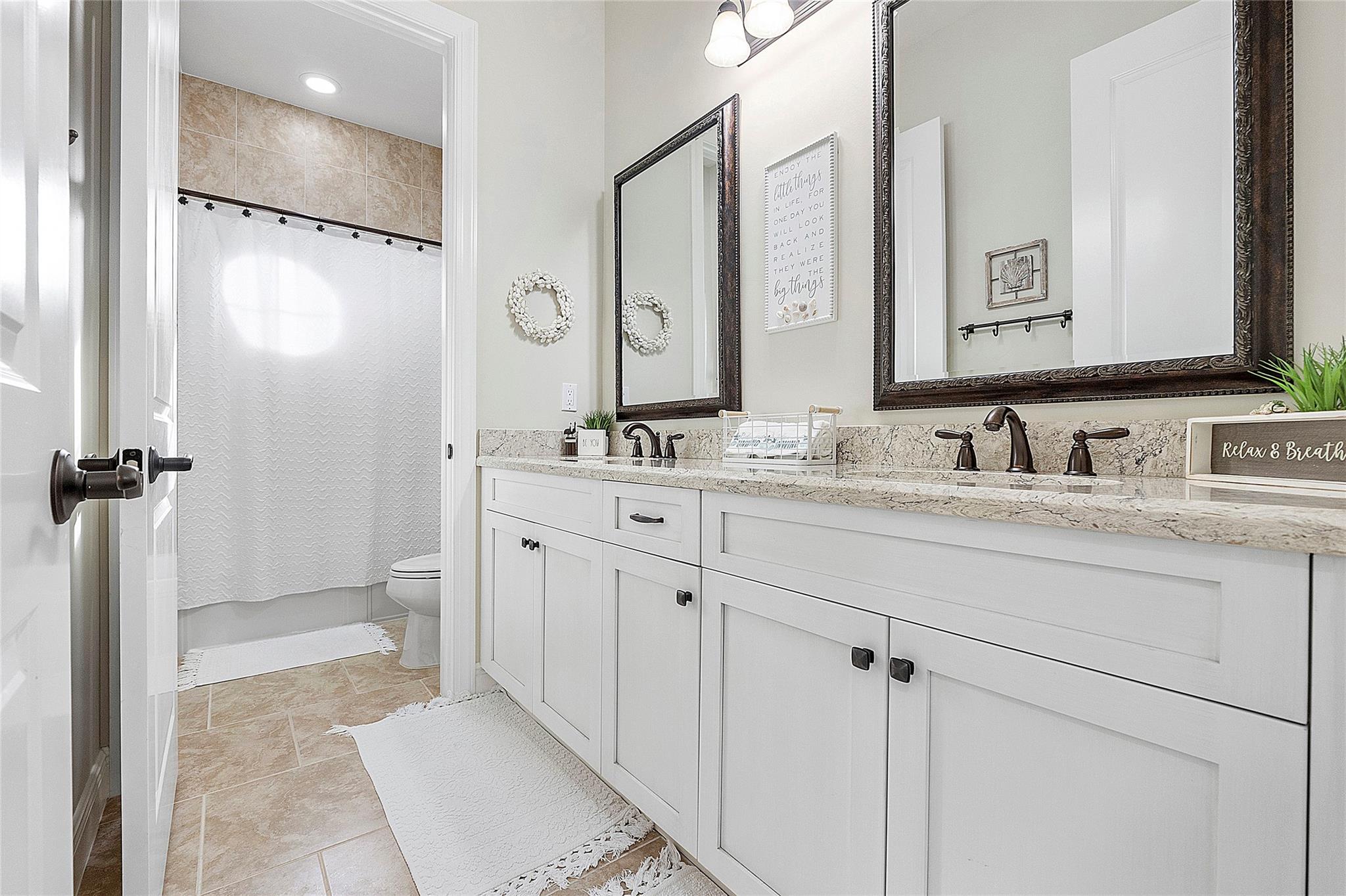 Double vanity upstairs full bathroom with separate water closet, Italian tile flooring.