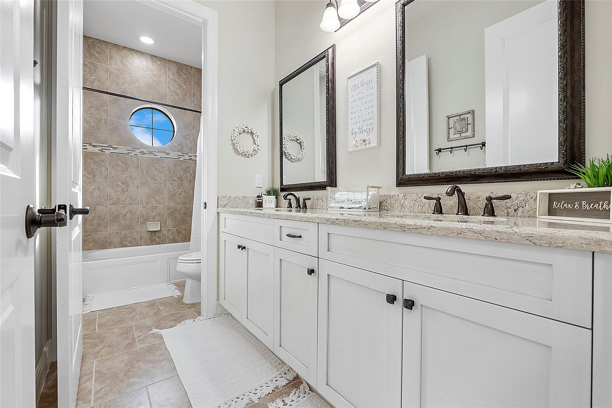 Pretty circular windows adorn this home with tub and shower water closet.
