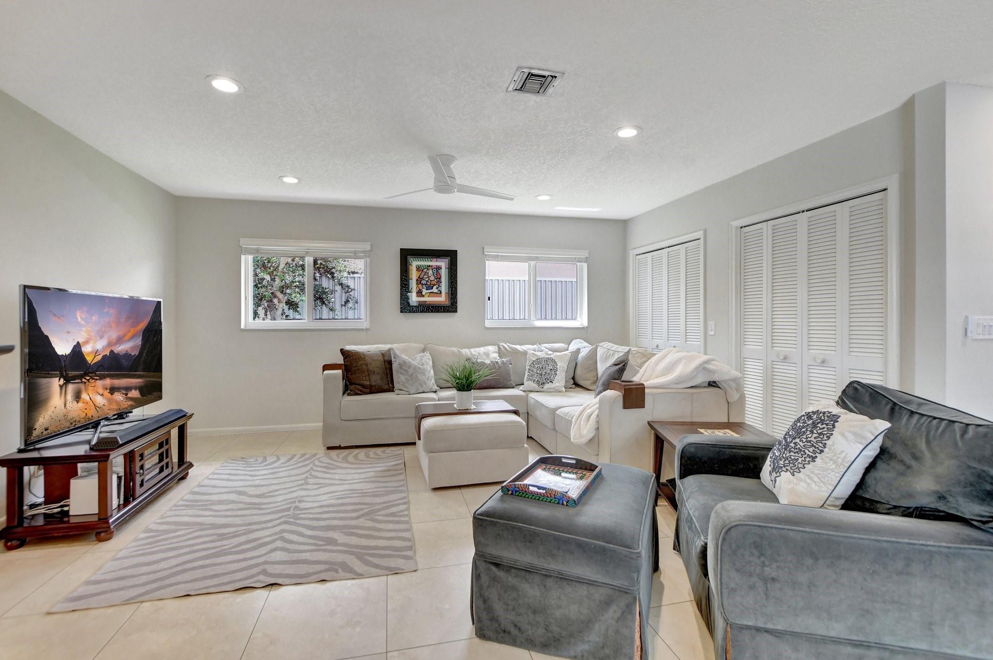 Large family/living room with lots of storage in the closets right behind couch.