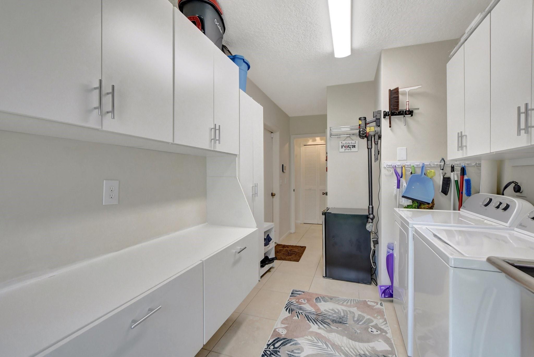 Extra large laundry room that has top to bottom custom built-in storage