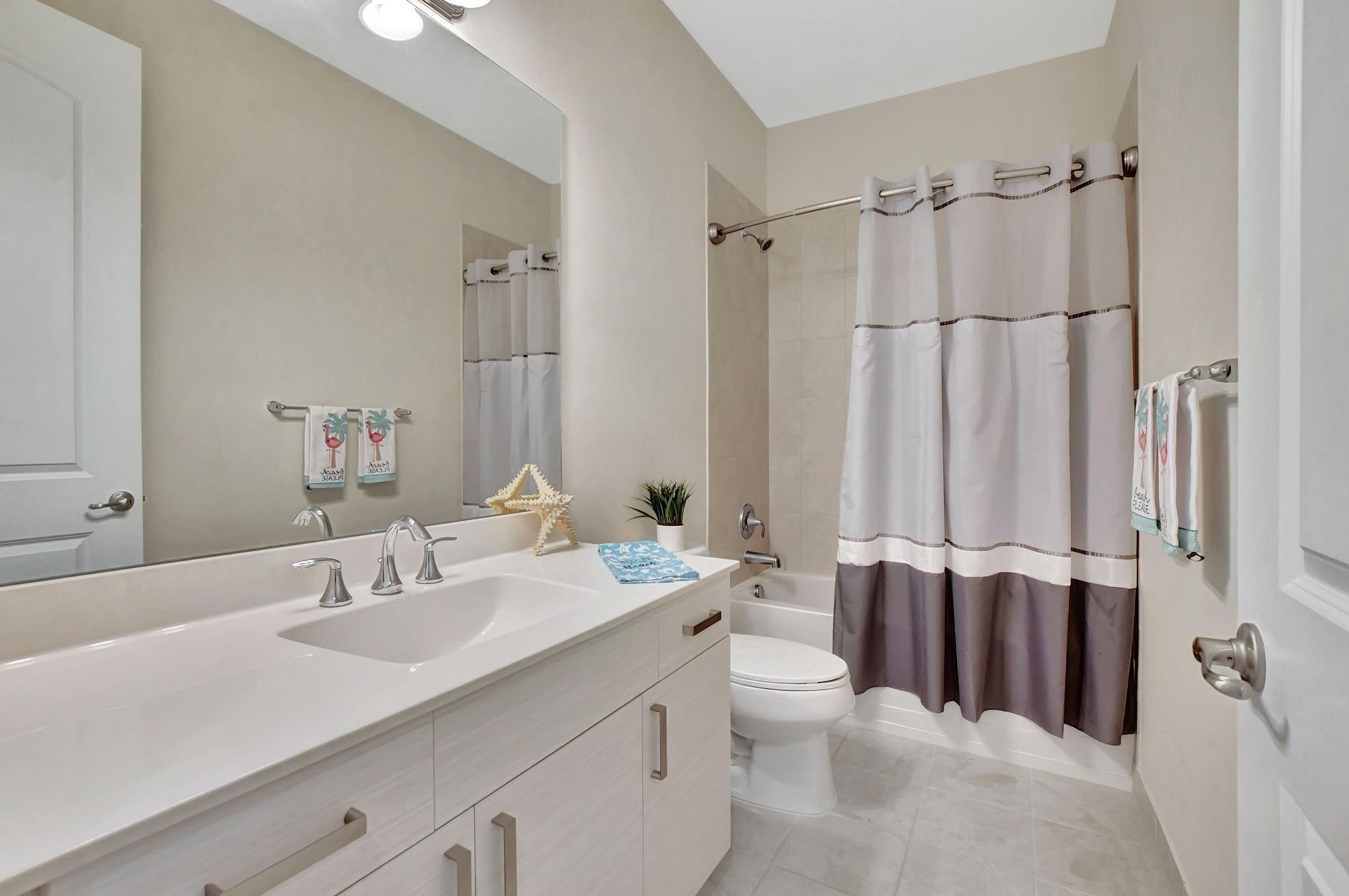 Guest bath features an extra long counter height vanity and a tub for the kiddos.
