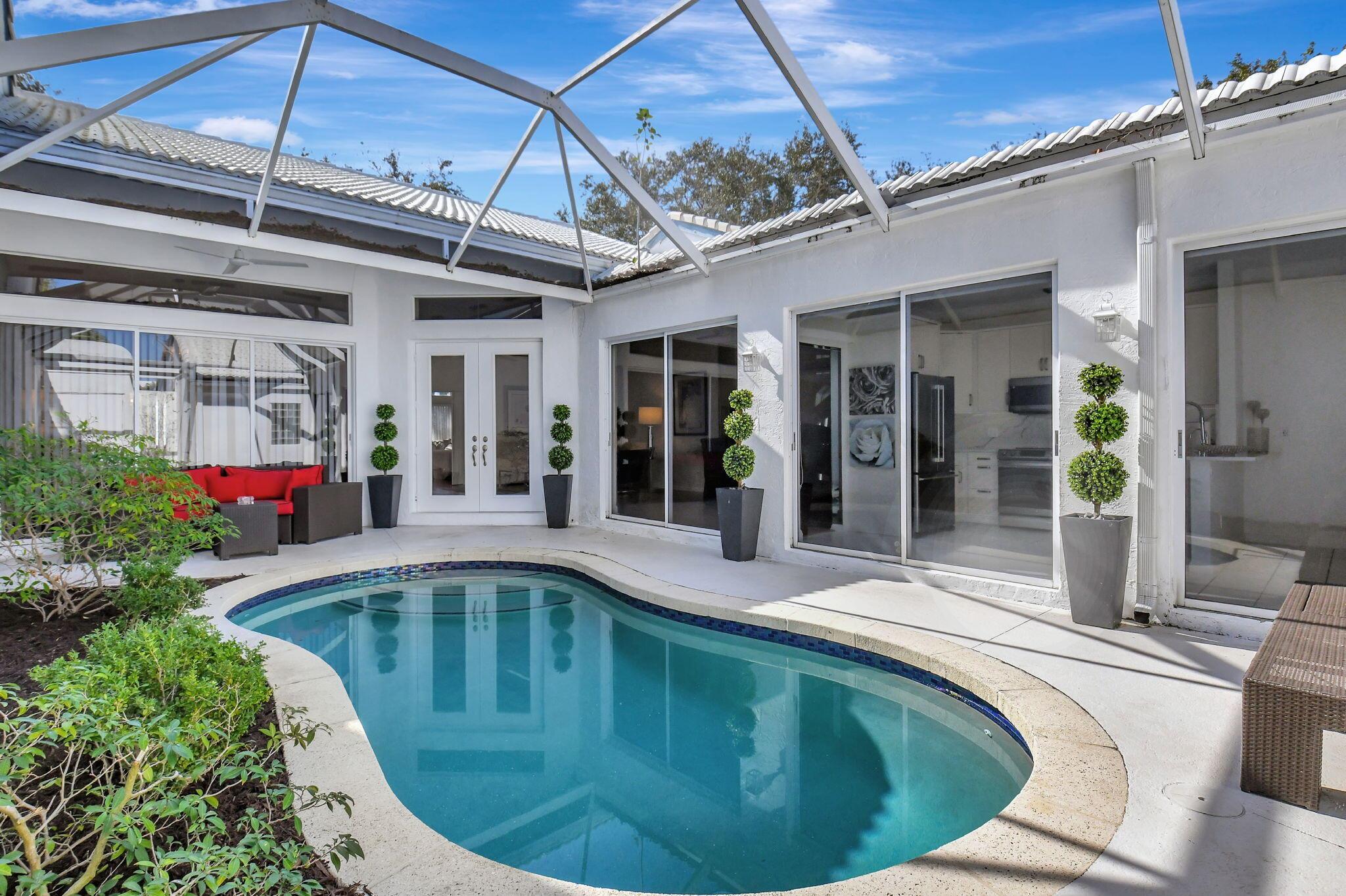 For OPEN HOUSE call agent for gate access. Welcome to your luxurious villa in the prestigious Mykonos in Boca Golf & Tennis! This exquisite 3-bedroom, 2.5-bathroom residence boasts a screened-in courtyard w/ heated pool ideal for serene relaxation and entertaining. Experience the elegance of high-volume ceilings and an abundance of natural light cascading through the home. The rich wood and tile flooring enhance the sophisticated ambiance. Kitchen features white custom cabinets,  quartz countertops, new Stainless Steel appliances. Floor to ceiling sliders offer stunning views of the sparkling pool. Two car garage for your convenience. Located within a gated community with non-mandatory membership, this stunning property is situated in a highly-rated school district.