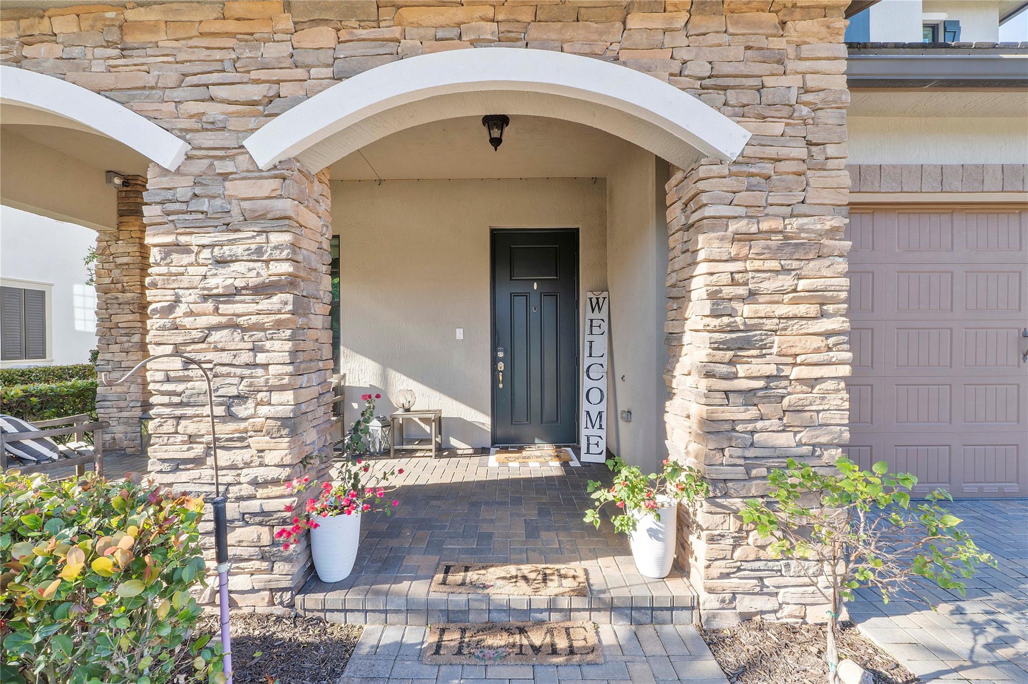 The exterior entryway has 2 stone arches and lots of room for a couch or rocking chair on the front pavered patio, Lots of people sit on their patio's at Watercrest watching the children play and people pass by walking their doggies,
