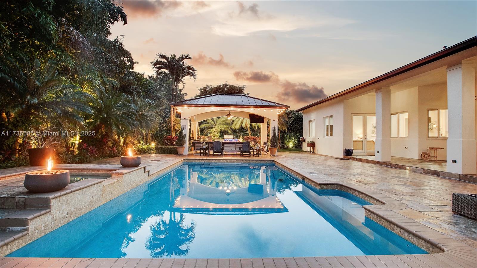 Discover this owner-built sanctuary in Palmetto Bay, offering 5 bedrooms, an office, and 5 baths across 5,319 sf. Meticulously maintained since 2008, this home features impact windows, high ceilings, marble floors, a lavish master suite and California closets. Step outside to a gorgeous patio overlooking the pool and lush, manicured garden, plus a fully equipped gazebo with an outdoor kitchen and coral rock firepit, perfect for entertaining. Recent updates include a 2021 roof, new A/C's and plantation shutters. Located on a quiet street near top schools such as Palmer Trinity and Westminster Christian, beautiful natural parks, and Biscayne Bay, this home blends luxury and comfort in one of Miami’s most sought-after communities. Your Palmetto Bay dream home awaits, schedule a tour today!