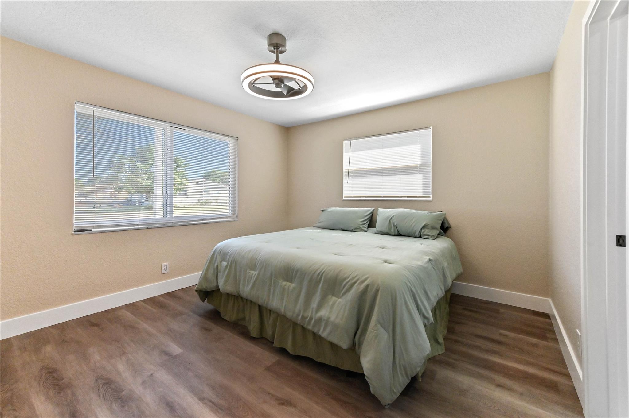 Spacious primary bedroom with wood style floors and 2 closets