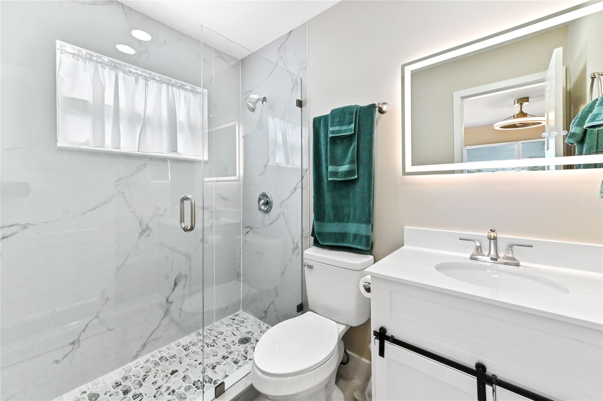 Primary bathroom with designer tile and frameless shower doors