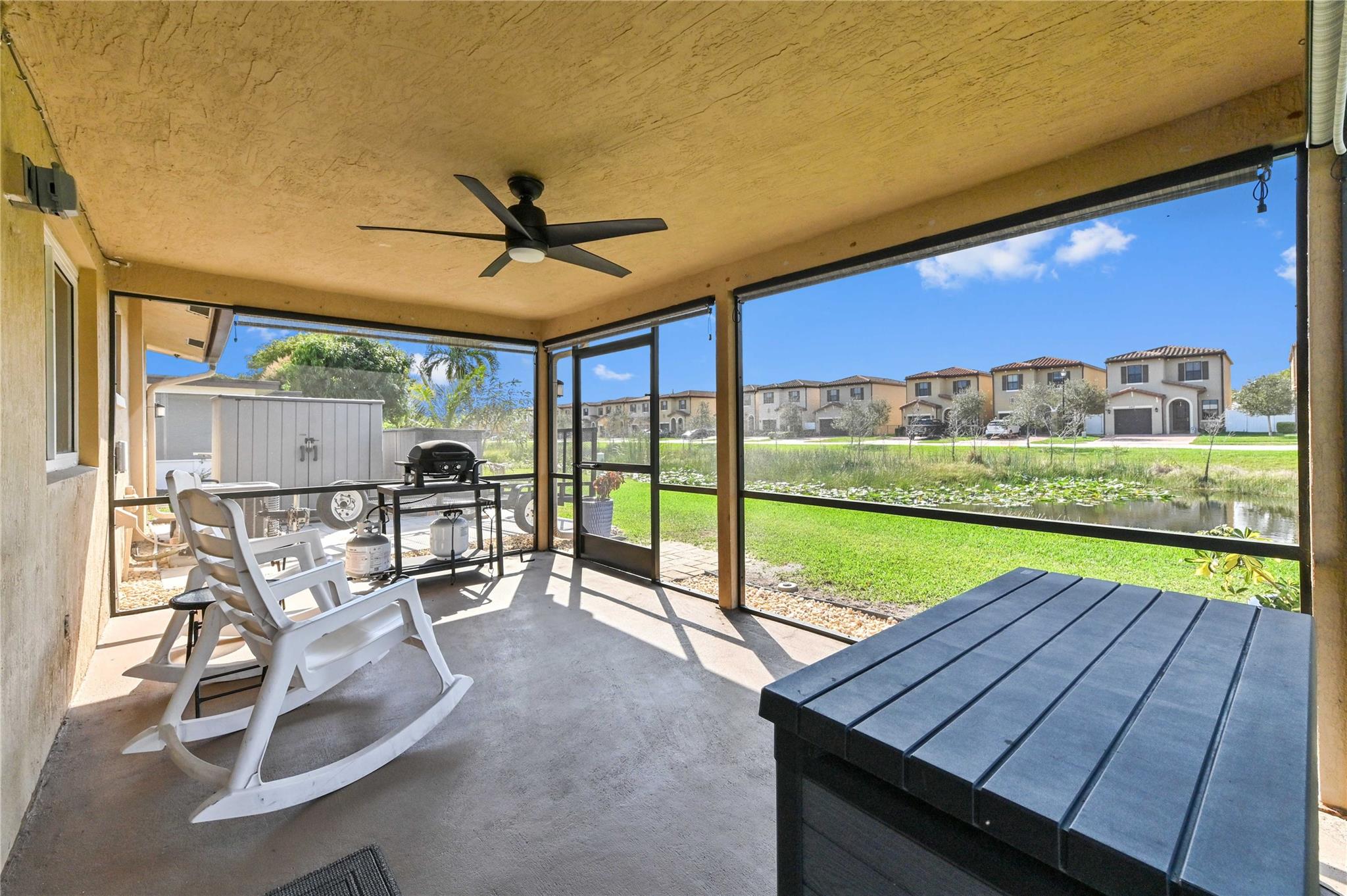 Large screened patio with ceiling fan overlooking canal