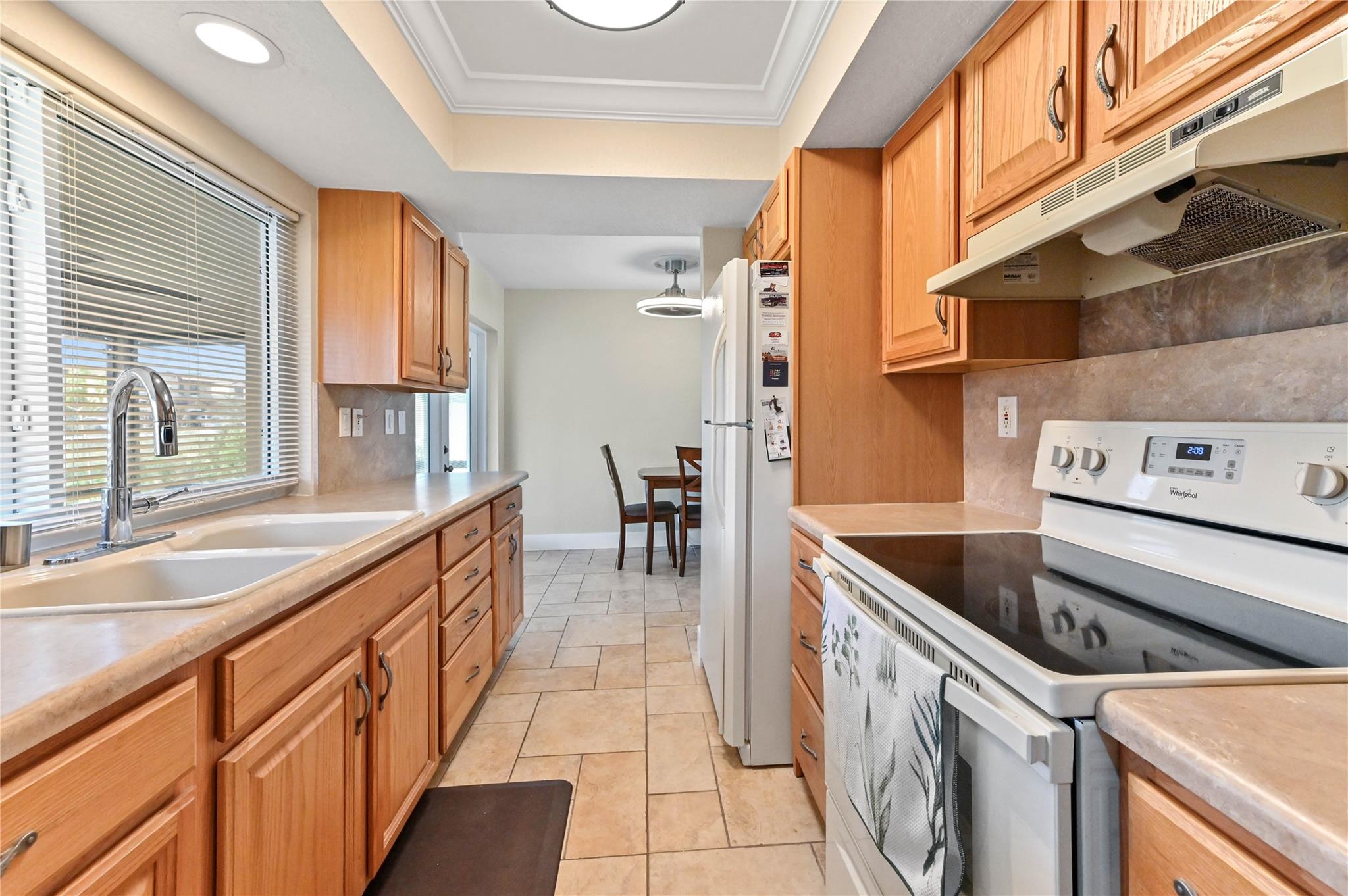 Kitchen with tray ceiling and smooth top range