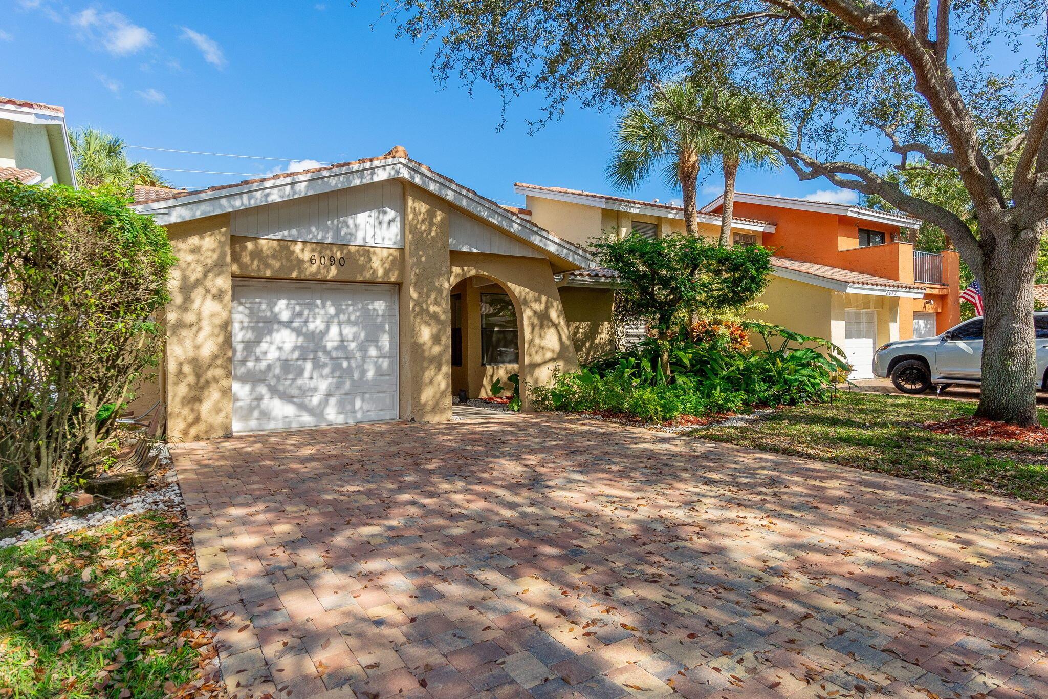 This charming home features 2 bedrooms and 2 bathrooms with beautiful tile flooring throughout. The kitchen, master bathroom, and second bathroom have all been remodeled to perfection. Enjoy the spacious living room with its vaulted ceiling, and relax in the cozy, private backyard. Conveniently located within walking distance to Boca Town Square Mall and close to FAU and Brightline. A/C(2023), New garage door opener. Renovated 2 car pavers driveway