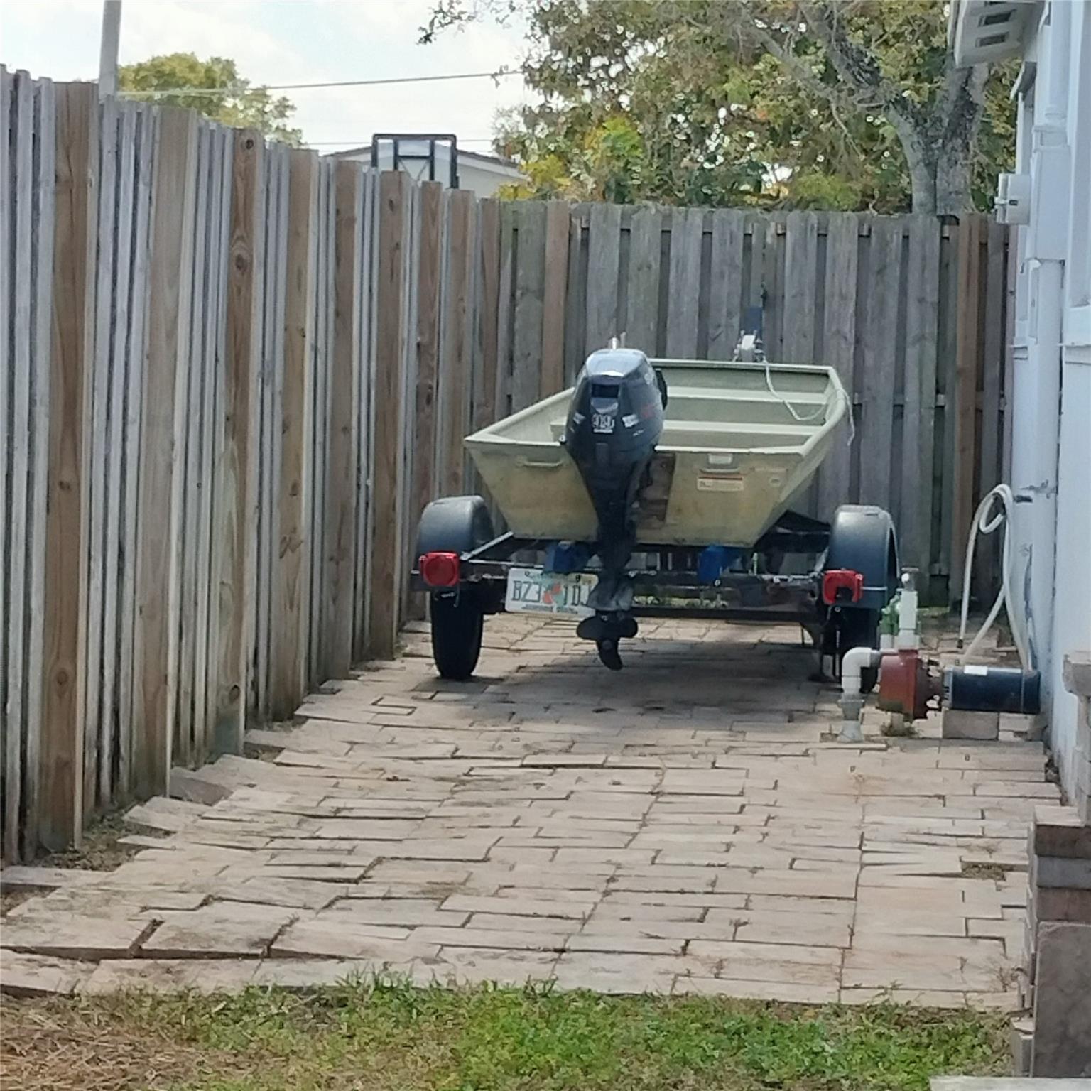 Pavered area on east side of house behind fence.
