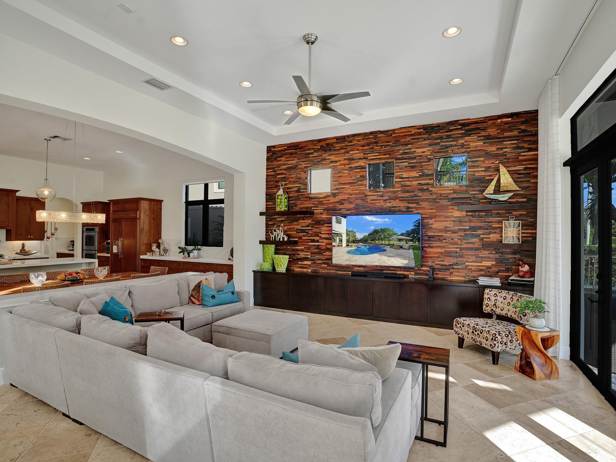 Very high ceilings define this beautiful home. The entire wall of the family room has been meticulously covered with wood, infusing the space with a warm, cozy, upscale, and well-organized ambiance.
